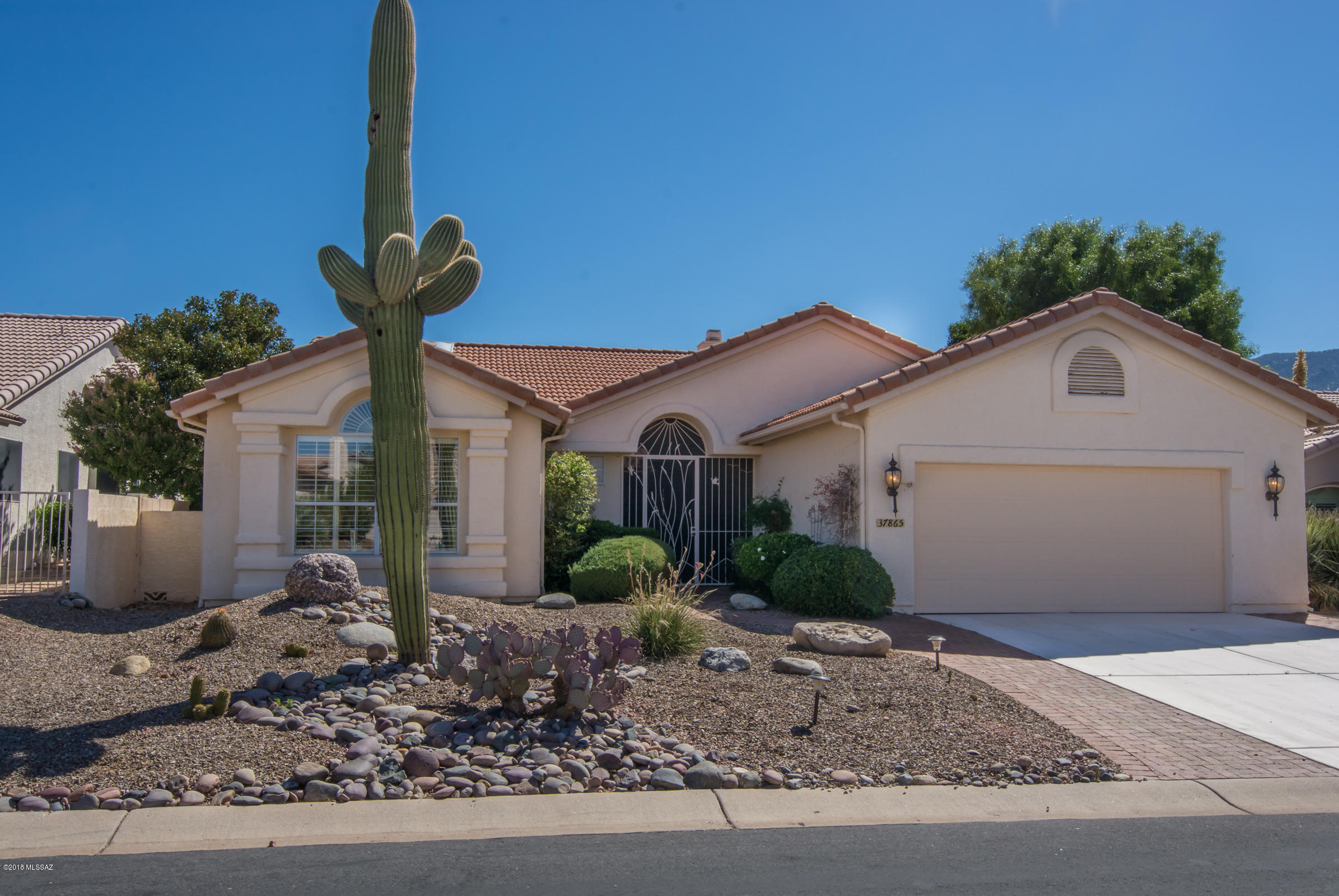 This exquisite Estancia has it all: optimum golf course and panoramic mountain view from a lovely patio with water feature. 2 bedrooms, Den, 2 baths (Master has been up-graded) See-through fireplace (living/family Rm.) Up-dated kitchen (island) with granite counter tops. Large laundry room with newer washer & dryer. Lovely window treatments, tile and carpet in the right places.
Work bench and loads of cabinets in garage. Come see for yourself! You will love it!
