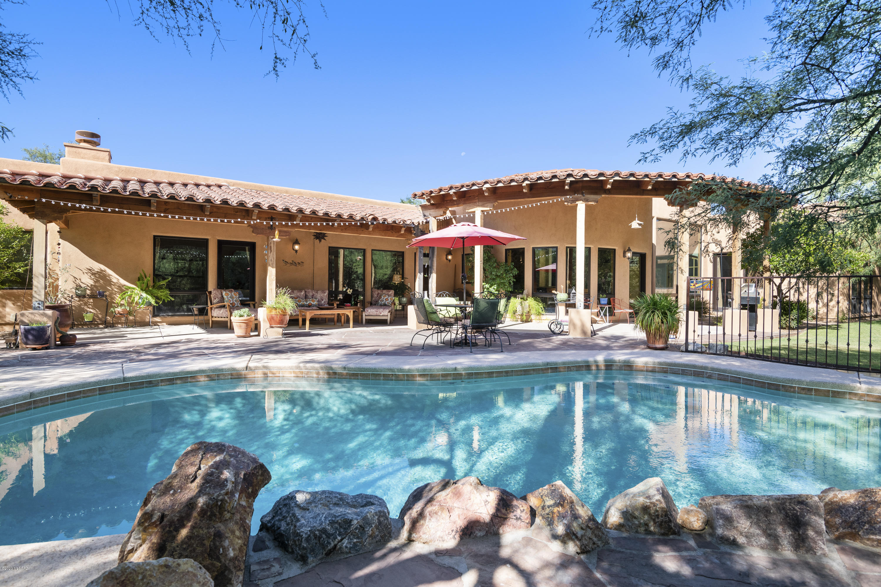 Upscale Mediterranean-Hacienda - An equestrian's dream & AZ living with great indoor/outdoor living. 3.5 ac of dense mesquite trees & saguaros. Perfect for families, multi-gen living & over-the-top entertaining. Horse arena with direct trail access, 2 room tack room, steel fencing, shade, with electricity/water at barn. Irrigated grassed back yard resort with gorgeous pool & shaded, flagstone patios & fountain. Features: Chef's kitchen - Viking 6 burner gas/convection stove & well-appointed finishes, real imported Merbau hardwood floors, solid alder interior doors, wood/alum clad Sierra Pacific windows, high wood beamed ceilings, spacious 5 bdrms, master with fireplace, jetted tub & huge closets, oversized 3-car epoxied garage with workshop/storage & dog run. Quiet country road. No HOA