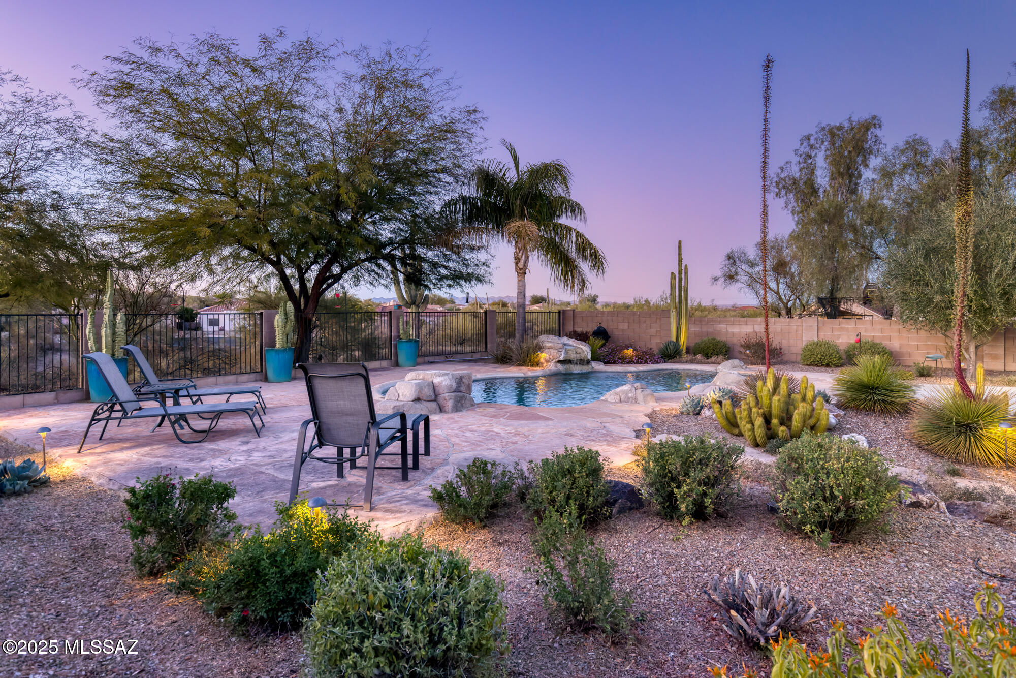 Nature, community & convenience converge at this exquisite property in the Tucson Mountains. Inside the gates of Sweetwater in the Foothills, a certified wildlife habitat, this location offers residents easy access to trails, open spaces and city amenities. Sitting on an elevated ¼ acre lot, 4092 W Tombolo Trail abuts open space with exposure to multiple mountain ranges. Meticulously renovated top to bottom with fine finishes, you will find a modern aesthetic that maintains a sense of warmth. The split floor plan includes 3 bedrooms, 2 bathrooms and an open living area which provides sightlines to greenery and mountains. Throughout, there are concrete floors, spa-like bathrooms with upgraded countertops, slab cabinetry, and professionally designed closets. Masterfully executed, the chef's kitchen includes custom cabinets extending to the ceiling, granite counters, induction cooking, commercial venting, a convection oven, built-in refrigerator and microwave, and pull-out shelving. 

The roof was replaced in 2020, and both the pool pump and water heater have recently been replaced. Other special elements include a potassium-based water softener, energy efficient LG laundry system, floor outlets, ceiling speakers, energy efficient lighting, and an electric vehicle charging in the garage.

An oasis is found in the backyard, which includes a full length covered patio, swimming pool with natural lines, mature desert plantings, and an herb garden. The experience is peaceful, with routine visits from owls and migratory birds, beautiful views, and excellent privacy.

The community provides a year-round heated pool, walking paths, a playground, picnic areas and opportunities to enjoy the desert and mountains. Nearby, Robins K-8 is within walking distance, while access to The Loop (multi-use paved path) or Christopher Columbus Park is about 2 miles. Multiple trailheads are nearby for hiking, mountain biking and horseback riding. Getting downtown or to the University is quick and easy, both are under 20 minutes.