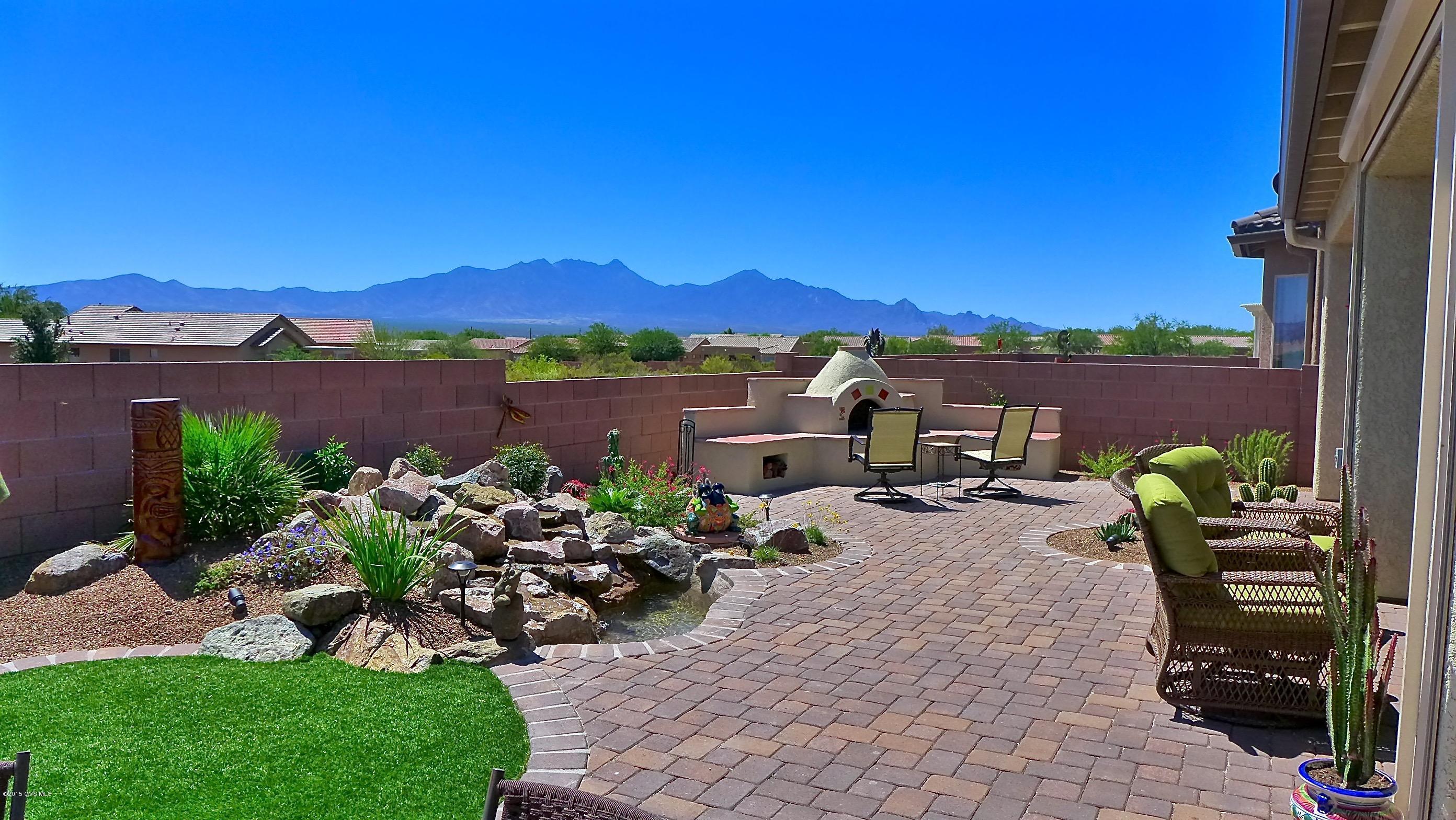 If a magnificent mountain view is important to you--look no further. This like new home has been gently used as the owners have only lived in it about 6 months. It has been built to impress with a long list of upgrades that includes granite counters, gas range, tile floors on the diagonal in all the right places, tiled shower, and so much more. You'll fall in love with the stunning views that can be enjoyed inside and out. The open concept floor plan is designed the way you want to live. Step outside to very own SW outdoor retreat and listen to the sound of birds that make their home in the common area behind the sounds and enjoy the sound of water from the large waterfall feature. Stay warm by the Kiva FP and get lost in the breathtaking views of the ever-changing Santa Ritas.