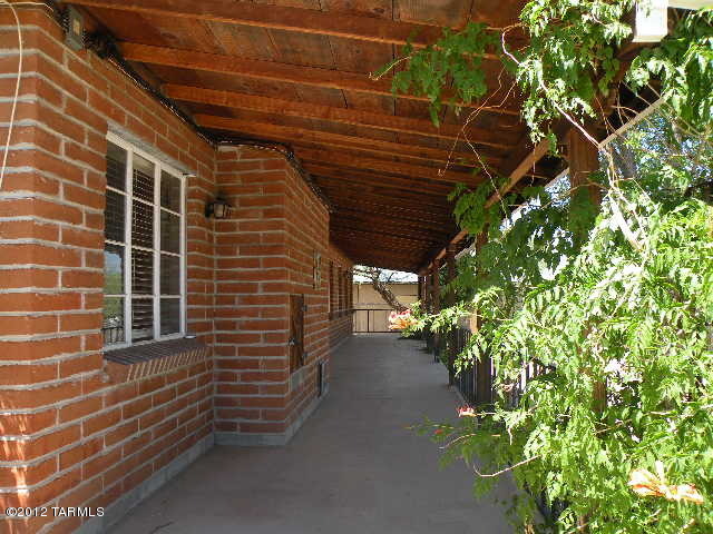 Known locally as the Mowry House, this handsome burnt adobe home in one the most desirable in-town locations sits distinctively on 4 lots just down from the historic ''Schoolhouse'' on the hill. It is fully fenced, has a concrete driveway, a shared private well, mature landscaping, and the old barn adds to the history and charm.  There is recently installed berber carpeting, a heat pump HVAC system and water softener.  In the kitchen are solid wood cabinets, there is a large fireplace in the living room, and the large covered porches front and back afford as much outdoor living as one likes. This is a MUST SEE property for the discerning buyer:  excellent ''walkability'', no flood insurance requirement and tasteful regional architecture.  Owner financing possible.