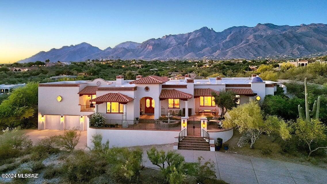 Welcome to a breathtaking masterpiece of architectural brilliance and exquisite design, nestled within the prestigious and secure enclave of La Puerta on Hacienda del Sol! Experience the art of living in this extraordinary all masonry Spanish Colonial estate, meticulously crafted by the esteemed master builder Mike Wachs as his own personal residence.

Perched high upon a hilltop, this residence offers unparalleled views, capturing the serene beauty of majestic mountains, the splendor of golden sunsets, and the glittering azimuth of city lights. This custom-built sanctuary is a testament to refined elegance, showcasing an assemblage of the finest materials available.

As you step inside, cross the threshold into an ambiance where luxury embraces warmth and comfort. Every detail speaks volumes from the intricate hand-carved beams and corbels to the gleaming hardwood floors and solid wood doors, each element is woven seamlessly into the fabric of this exceptional home.

Delight in the seven fireplaces that infuse every room with cozy sophistication. For the automobile connoisseur, five-car garage stands are ready to house a cherished collection, while the entertainer's kitchen serves as the heart of opulent gatherings, fully equipped to inspire culinary creations that rival any gourmet experience.

Work or leisure, the expansive library/home office is a sanctuary for the intellect, lined with floor-to-ceiling wood bookshelves. Further entice your guests with a chic wet bar, designed to accommodate soirées of any magnitude, offering a sophisticated touch to your hosting endeavors.

The separate guest house ensures privacy and luxury for visitors, echoing the elegance found throughout the main residence. Everywhere you turn, expertly crafted wood windows frame mesmerizing views, ensuring nature's splendor features prominently in the design.

This timeless masonry-stucco construction is accentuated by a charming brick cap, imparting a classic allure to this stately abode. Step outside to discover a phenomenally landscaped paradise, where extensive pavers guide you through exquisite outdoor living and dining spaces designed for tranquil relaxation or lavish entertaining.

Unwind by the captivating pool and spa, perfectly poised to offer jaw-dropping vistas, redefining the concept of an outdoor oasis. As a remarkable complement to this estate, the sale includes an additional 2.3-acre buildable lot, offering endless possibilities and guaranteeing uninterrupted panoramas.

Here at this hilltop estate, luxury is not just a lifestyle but a grand experience. It's a rare opportunity to indulge in a residence where every moment is nothing short of extraordinary.

Contact us today to arrange a private showing and take the first step toward making this unparalleled residence your own, where elegance, prestige, and an extraordinary way of living await!

Home can be purchased with adjacent 2.3 acre lot. Lot can be purchased for $500,000.