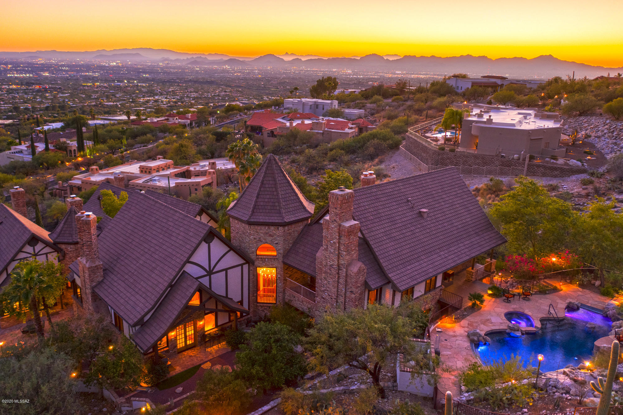 If your dream places you before a roaring hearth as you sip your favorite drink; or has you sitting poolside in complete relaxation, surrounded by Desert backdrop; and enjoying brilliant sunshine, dramatic moonrises and fiery sunsets, you'll be at home, at last, in this one-of-a-kind Normandy Tudor home. 
This luxury homestead, known as Mission Hill, a 9100 sqft estate, is sheer elegance and enchantment, personified. The property backs into the ancient terrain of the Coronado National Forest, occupying a generous 4.3 acres, which provides a sweeping 360 degree, 8-view point picture at its highest elevation of the surrounding saguaros, rock outcroppings, and the glimmering city lights and downtown skyline of Tucson, stretching as far as the eye can see! Gracious and elegant and majestically ethereal, Mission Hill rises above the Skyline Country Club community, a guard-gated enclave of 300 luxury homes, with many amenities including golf and fine dining. Constructed in 1987 this hilltop mansion is a custom Normandy Tudor designed residence that is recognizable by its signature architecture, steep roof pitches, decorative half-timbering; high ridge lines, dual turrets and dormer windows, emphasizing the appearance of a grand scaled estate. The exterior of the home, walkways, patio and outdoor kitchen of the were completely constructed with Chicago Brick; taken from an old Chicago warehouse, adding to the property's immense charm and value. The Grand Foyer ushers you on the beautiful travertine floors into the magnificent Great Room and its exquisite focal point, the fireplace. This is just one of 7 fireplaces in the home! The oversized Great Room comes complete with its own mezzanine area that offers endless possibilities, like a private library or displaying art work. Absolute luxury with elegant finishings, wood plantation shutters and travertine throughout.
The large, pleasing, authentic Normandy Tudor style kitchen is sure to be the place where friends and family want to gather! It is beautifully appointed with bay windows, richly stained cabinetry, durable granite countertops, and tiles covering the floor. The glorious walkways, well-maintained grounds, the award winning, sparkling Pebble Tec Pool with spa, surrounded by two waterfalls, and located close by is a Pool Suite with two full baths and kitchen facilities, will surely encourage you to live outside, as much as inside!
The home also has detached Guest Quarters comprising of a roomy 1,505 square-feet, two bedroom, one bath Guest House with full kitchen and Great Room. In addition, a Guest Suite with kitchen and bath is located right above the huge three-car garage. This is wonderful for friends, business colleagues, extended family or could be used as amazing investment opportunity. Rebuilding this home would cost double the list price. 
Call us today for your guided private tour of this magnificent estate.