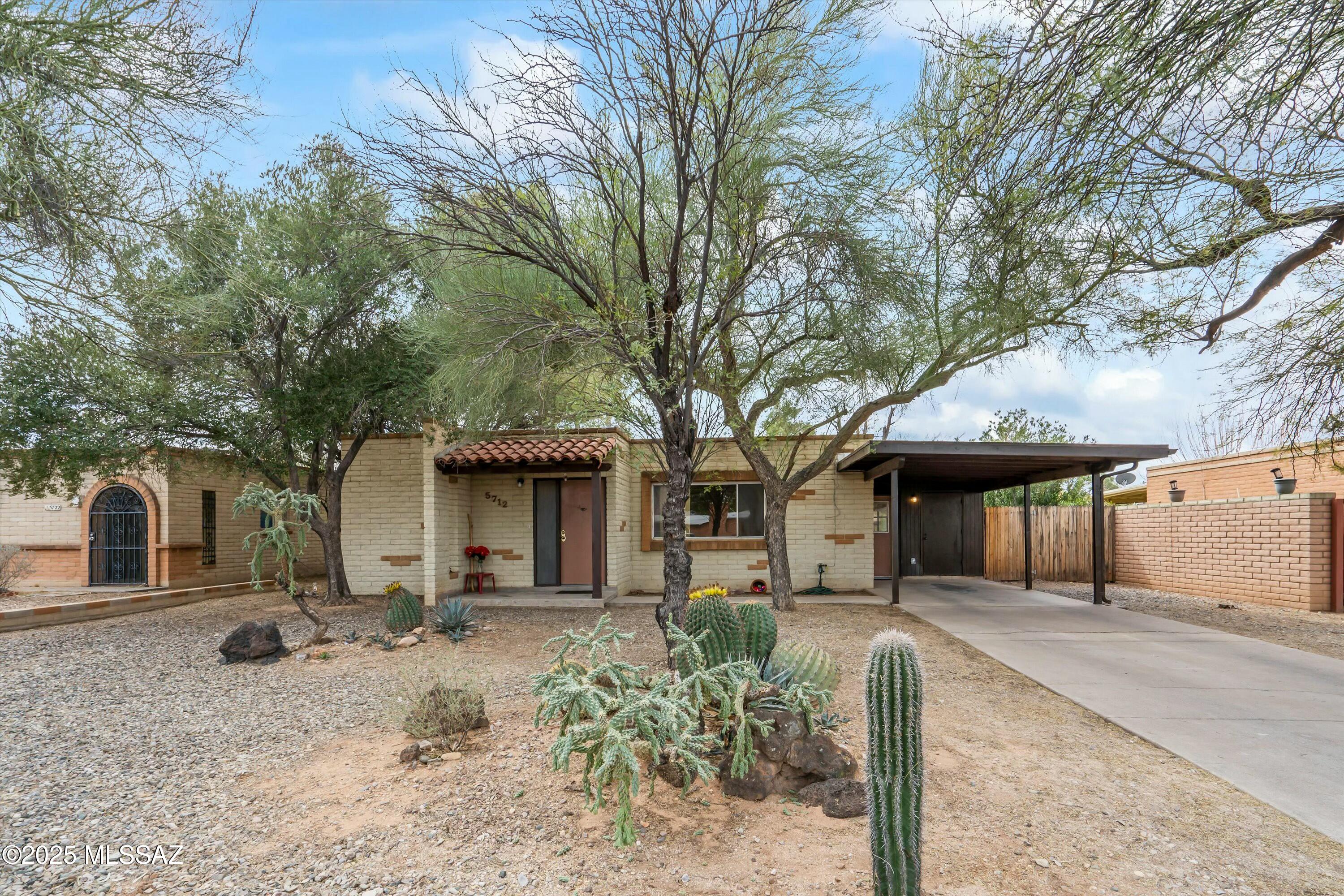 Charming Tucson Territorial Home with Endless Potential! Step into this inviting mid-century brick home, nestled in a peaceful Tucson neighborhood. Boasting 4 spacious bedrooms, 2 bathrooms, & exposed brick walls, this home is filled with natural light & ample space for entertaining. The large living area features original concrete floors, while the kitchen offers classic cabinetry, a mosaic backsplash, and generous counter space. A spacious enclosed patio extends your living space for indoor-outdoor Arizona living. The primary suite provides a relaxing retreat, and additional bedrooms are perfect for guests or a home office. Enjoy a low-maintenance desert landscape, covered carport, and extra storage. Located near parks, dining, shopping, TMC and Costco. HVAC 6 years old 2019.