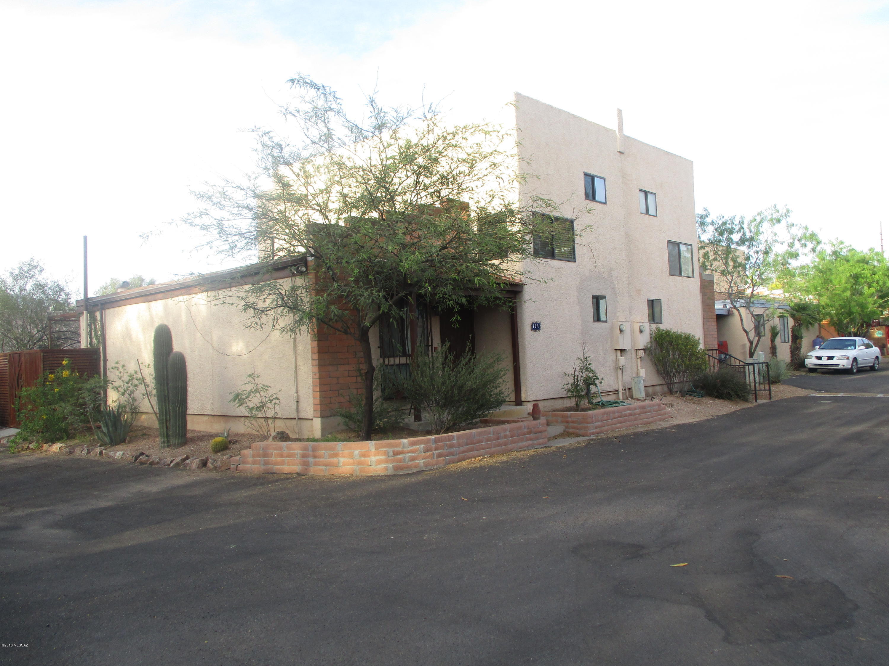 Make this home!  Incredible finishes in this extremely well located town home in a private community.  Biking distance from U of A, this 2 ba/2bd plus office home has tons of upgrades including wood floors, plank & bean ceilings, new cabinets, new appliances, quartz counter tops, glass vanity/sink, new windows, jetted tub, custom tile bath surrounds.  Tile in the kitchen & bathrooms with special detail finishes.  A/C & incredible mountain views.  Lots of closets & storage space. Bedrooms have double closets.  Custom wrought iron work on the windows & doors.  End unit.
