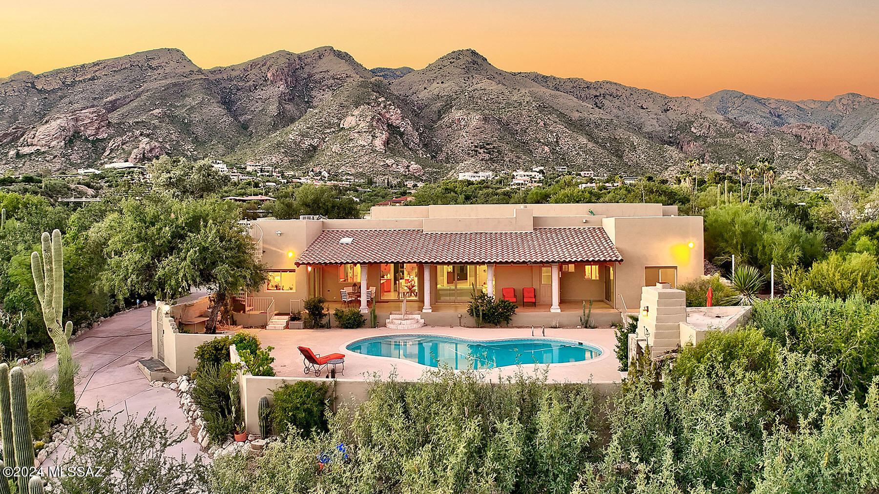 Situated on 1.1 private acres within the prestigious, guard-gated Skyline Country Club Estates, this exquisitely remodeled Southwestern contemporary home offers 4,835 sq. ft. of living space with breathtaking panoramic views of the mountains and city skyline. Completely reimagined between 2016 and 2017, this four-bedroom, four-and-a-half-bath residence (including three en-suite baths) blends timeless elegance with modern sophistication.
Step into the expansive living room where soaring ceilings and designer ceramic tile flooring create an inviting sense of grandeur. The formal dining room, with its dramatic vaulted ceiling, comfortably accommodates 12 or more guests—perfect for entertaining on any scale.
The spacious family room, open to the gourmet kitchen, features a cozy fireplace and a large Pella retractable sliding door that seamlessly connects the indoors with the stunning outdoor living areas. Designed for the discerning chef, the kitchen boasts sleek quartz countertops, high-end self-closing cabinetry, and a convenient butler's pantry.
Retreat to the serene primary suite offering tranquil mountain views, a custom walk-in closet with built-ins, bamboo flooring, and a luxurious bath complete with a bidet. Three of the four bedrooms feature bamboo flooring, while the bathrooms are appointed with travertine tile showers and flooringcomplemented by marble tile in the fourth bath.
Additional highlights include a single-level floor plan with no interior steps, two AC units plus a mini-split in the guest bedroom, and an oversized three-car garage.
Step outside to enjoy a beautifully designed backyard oasis featuring an expansive covered patio, a sparkling pool, a striking outdoor fireplace, and a spiral staircase leading to a rooftop deck with spectacular 360-degree views. The meticulously landscaped grounds offer walking paths lined with mature trees, lush desert foliage, and majestic saguaros.
As part of the Skyline Country Club community, residents also enjoy access to top-tier amenities including golf, lighted tennis and pickleball courts, a pool, spa, and a state-of-the-art fitness center.