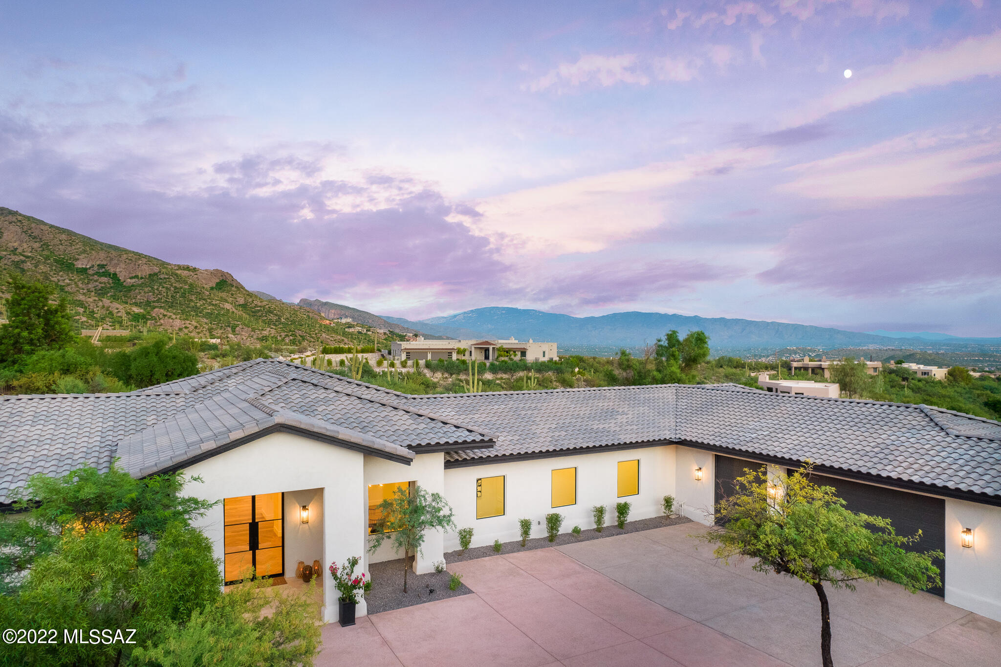 A sophisticated and perfectly executed blend of modern cutting-edge design and timeless architecture is found in this stunning like new Contemporary Foothills Masterpiece. After a nearly two-year complete top to bottom renovation, this home has not only been re-built to the highest of standards but was also completely re-imagined and re-designed by Scottsdale based builder, Norton Luxury Homes, leaving no detail unfinished. This contemporary showplace sits on a prime view lot in coveted Finisterra Estates, offering majestic mountain views towering above and twinkling city lights below. As you enter through the custom double glass entry doors, you are immediately drawn towards the great room which has a ''wow factor'' that is off the charts!   Enjoy the lush desert landscape and private canyon views from walls of floor to ceiling windows in the great room and primary suite that perfectly frame the natural view. The kitchen will leave you speechless and wishing you knew how to cook with the latest & greatest Wolf & Sub-Zero appliances, gorgeous custom cabinetry, spectacular stone countertops & backsplash and a butler's pantry sure to please your most discriminating caterer or private chef. The interior is simple yet elegant with clean lines and is accentuated by the tall ceilings, white walls and breathtaking wide plank French Oak floors throughout. The primary suite features a stacked stone fireplace in the private reading nook and a bathroom finished in luxurious Carrera marble w/free standing soaking tub, a walk-in shower large enough for two (or three) and an enormous closet complete with laundry hookup for 2nd washer/dryer. Inside you will also find a private home office, intimate dining room w/stacked stone fireplace, powder room, ample space for a large art collection, two oversized guest bedrooms both complete with private bathrooms and large walk-in closets, and a gorgeous yet functional laundry room w/custom cabinets & tile work. Zoned heating & cooling w/three new top of the line Trane HVAC units, two on demand tankless hot water heaters, new tile roof, new electrical, new plumbing, new septic system and a three-car garage with oversized doors and high ceilings that can easily accommodate lifts for additional car storage. Outside you will find a large entertainment deck with built in gas BBQ grill, ideal for year-round al' fresco dining under the stars.  Relax and enjoy your own private heated negative edge Pebble Tec Pool & Spa, with travertine pool surround. Low maintenance landscaping is accentuated by lush desert plantings, mature trees and artificial lawn for water conservation. Situated behind the maned gates of Finisterra, this coveted Foothills neighborhood offers 24/7 security, a heated community lap pool/spa, tennis courts, pickleball courts and a private clubhouse.  Convenient central Foothills location just minutes from Ventana Canyon Country Club, La Paloma Country Club, Whole Foods & La Encantada, for fine dining and shopping.