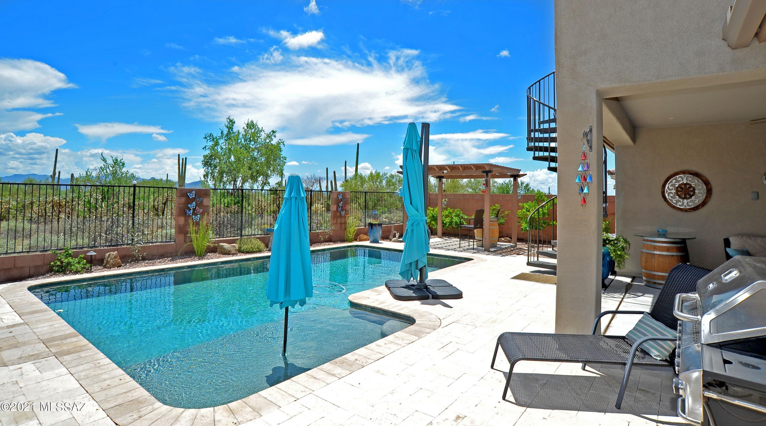 Mattamy 2017 PERALTA model, 2 Bedroom + office, 3 bath, 1810 sq. ft. home has it ALL!  Sparkling pool, Ramada, Rooftop patio with sunrise & sunset views, 12-foot sliding back patio doors which brings the indoors/outdoors on those Tucson days and evenings.  Upgraded LOT with desert /wash area behind the home, so no rear neighbors!!!
 The brick paved driveway & courtyard with custom wrought iron entry gate & water feature. The interior is so immaculate with a split bedroom plan, plantation shutters, ceiling fans, neutral paint, and beautiful ceramic tile with a wood look! The gourmet kitchen boasts a 5-burner gas cooktop/hood, Large granite island for any gourmet Chef tastes!  Upgraded Maple 42'' cabinetry w/custom backsplash, double ovens, microwave, with Island with ample bar seating The owner's suite is equipped with a custom ceiling fan, plantation shutters and upgraded carpet/pad. The master bath has double sinks, custom oversized walk-in shower with Travertine tile and obscured glass for easy clean-up and large walk-in closet.  The den & guest bedrooms are a nice size with custom ceiling fans, plantation shutters, upgraded carpet and pad, with plenty of windows to allow in the natural light. Welcome Home!