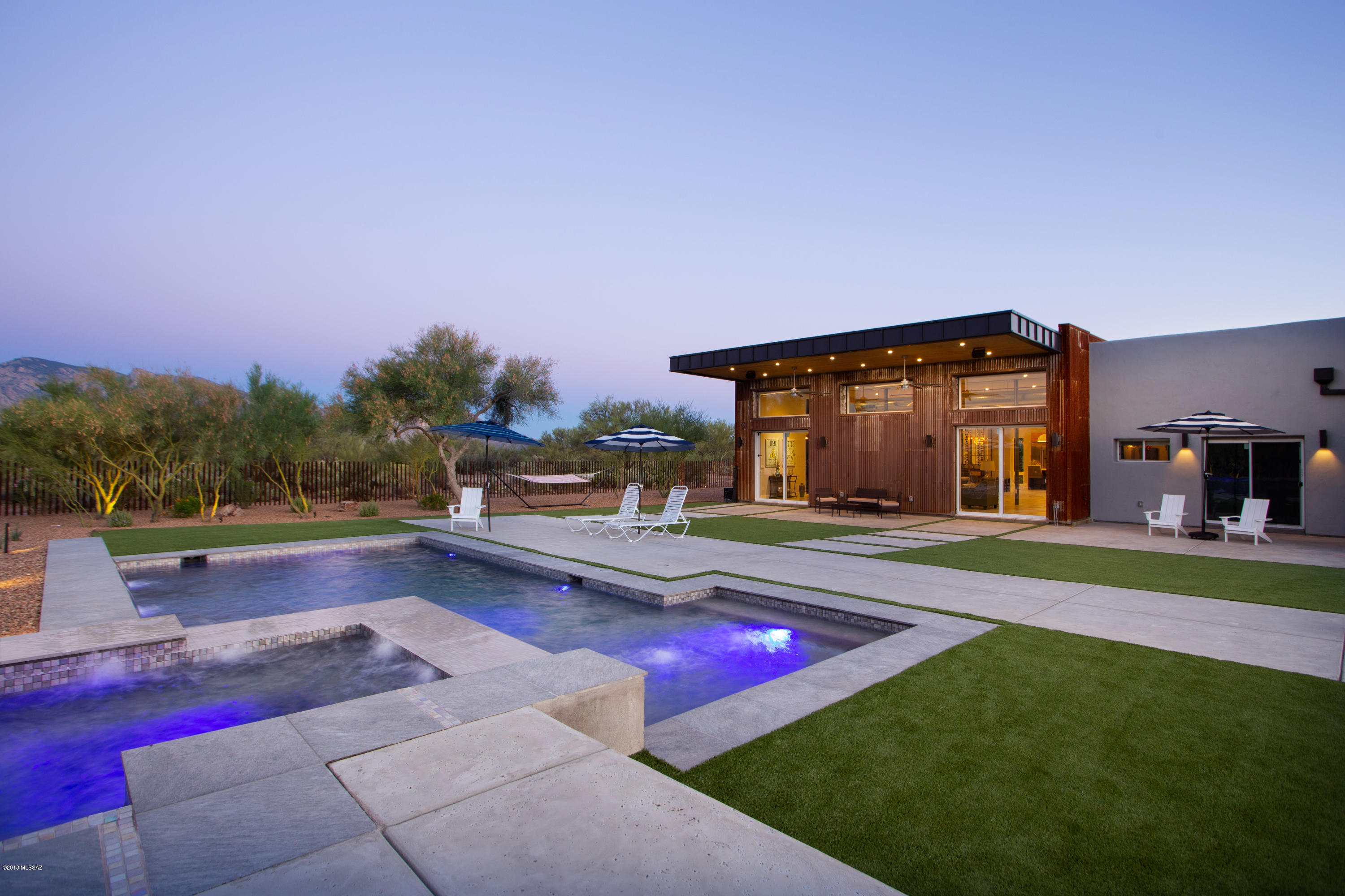 Extraordinary and unique gated estate located in La Cholla Airpark. Completely remodeled and expanded to over 4300 square feet utilizing high efficiency construction techniques and materials. Gorgeous High-end contemporary industrial elegance at its best with exposed ductwork and fire suppression system! Features walls of glass, concrete floors, custom sliding metal barn doors and wood burning stove. Open designer kitchen, huge Island, custom cabinets, 48'' 6 burner gas stove top with griddle, 48'' Viking Fridge, wall oven and built-in cappuccino/espresso machine. Elegant outdoors with large entertaining patios, built-in BBQ grill as well as a brick pizza oven which connects to your private oasis with sparkling salt-water, heated, self-cleaning pool with lagoon & spa. Endless mountain view