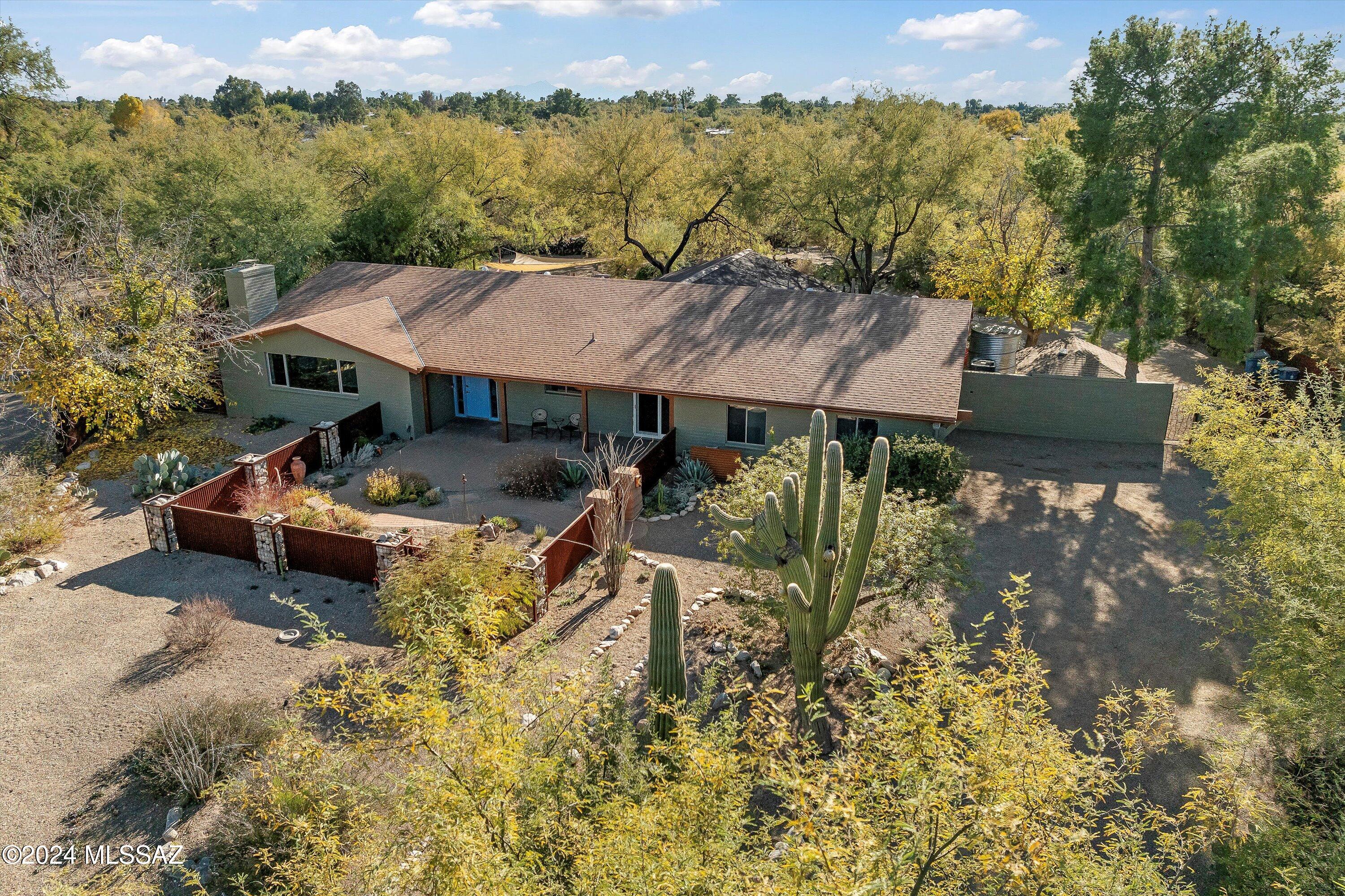 Welcome to a desert oasis in the Catalina Foothills! Situated at the end of a cul-de-sac on 1.18 acres, this 2,770 sq. ft. home features 4  bedrooms, 3.5 baths, a great room, plus an additional living space or home office.  Designed with equestrian enthusiasts in mind, the property features horse facilities, a tack room, arena & round pen, with convenient access to the Rillito wash for riding.  Outdoor living is elevated with a swim spa, vibrant gardens cultivated by a professional gardener & ample room for entertaining.  Inside, the open floor plan flows seamlessly, featuring an updated kitchen & baths, generous living areas & stylish finishes. This serene retreat combines privacy, functionality & natural beauty. A true gem for those seeking a lifestyle property. A rare opportunity! The home has brand-new interior & exterior paint. Don't miss the community pool!