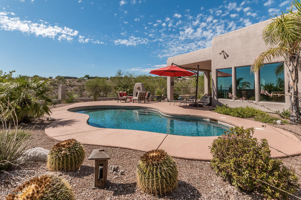 NOW CONTINGENT. This home is spectacular in every way! Located one mile from world famous SABINO CANYON, 4 bedroom 3 bath home has 3,170 sq ft with upgrades simply everywhere. Travertine tile, top line granite counters, staggered kitchen cabinets, high-end stainless steel appliances, high coffered ceilings, walk in pantry & spacious rooms make this home very special. Note the living room fireplace, and large laundry room with sink and cabinets. Motorized solar screens too, and a 3 car garage. From the large sparkling pool enjoy superb city and mountain views and a wood burning fireplace. Note the 2 large private covered patios for entertaining.  Close to everything - TMC medical, world class golfing, hiking, biking, and fine dining. EZ access to downtown and cultural events. Come see it!!