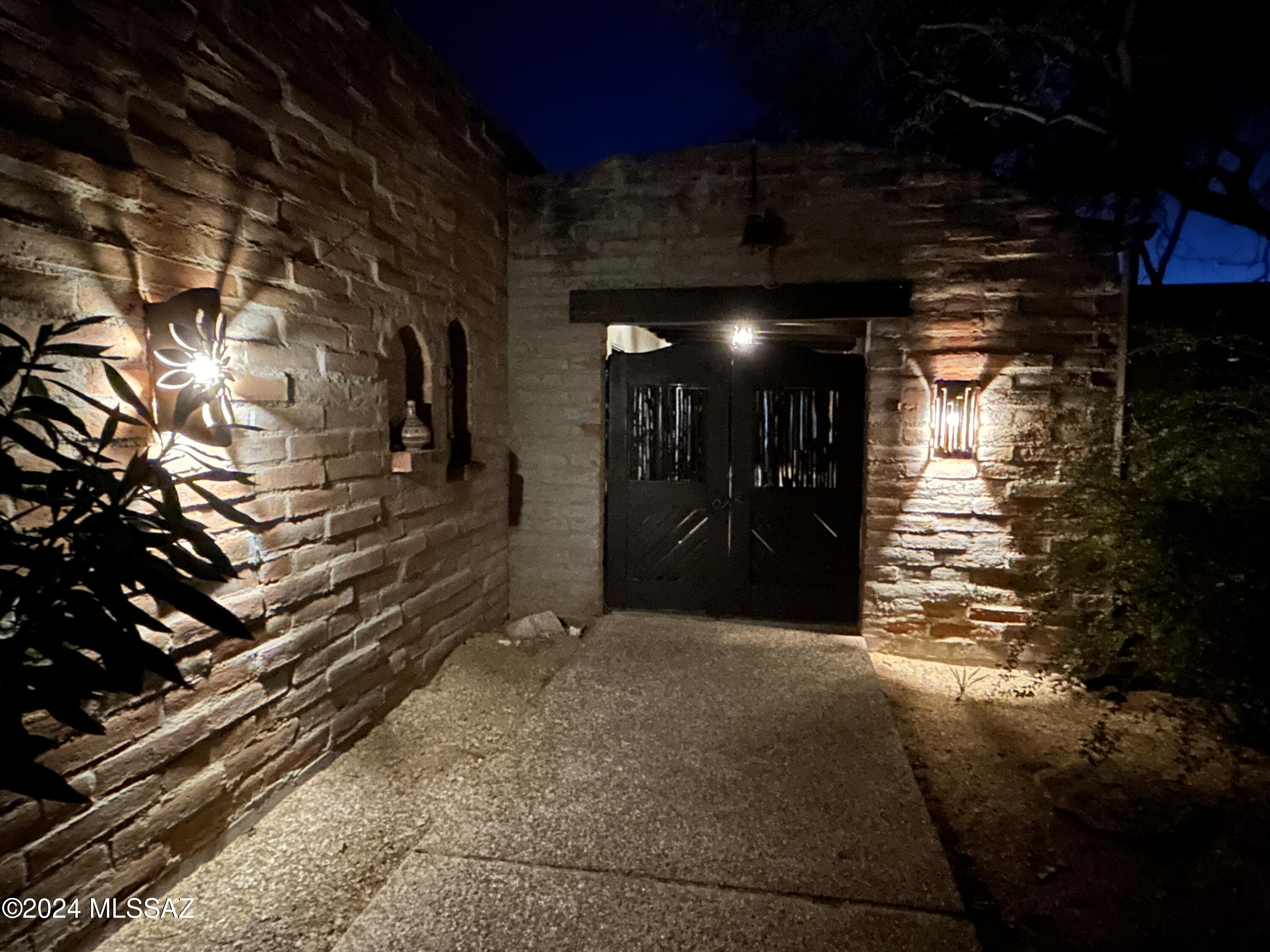 Quintessential  Tucson Territorial Home with plenty of historic charm and modern comforts on a very private 1.6 acres with 365 degree views from A-Mountain to the Catalinas.  There is NO HOA. The home was designed and built by the artistic husband and wife team of Tom Hill (Tucson Seven top artists) and Wanda Hill (Sculpture/metal arts-lighting).  
The architecture incorporates burnt adobe brick, timber beams with rough-sawn plank ceilings, and red polished concrete floors. Interiors spaces are structured around a courtyard. There are 2 master suites one with its own kitchenette and the other with an outdoor shower and fireplace.  There is a 2 car garage and carports for additional covered parking. 
The present owners updated the bathrooms,  kitchens, and HVAC  in 2015.  New roof in 202