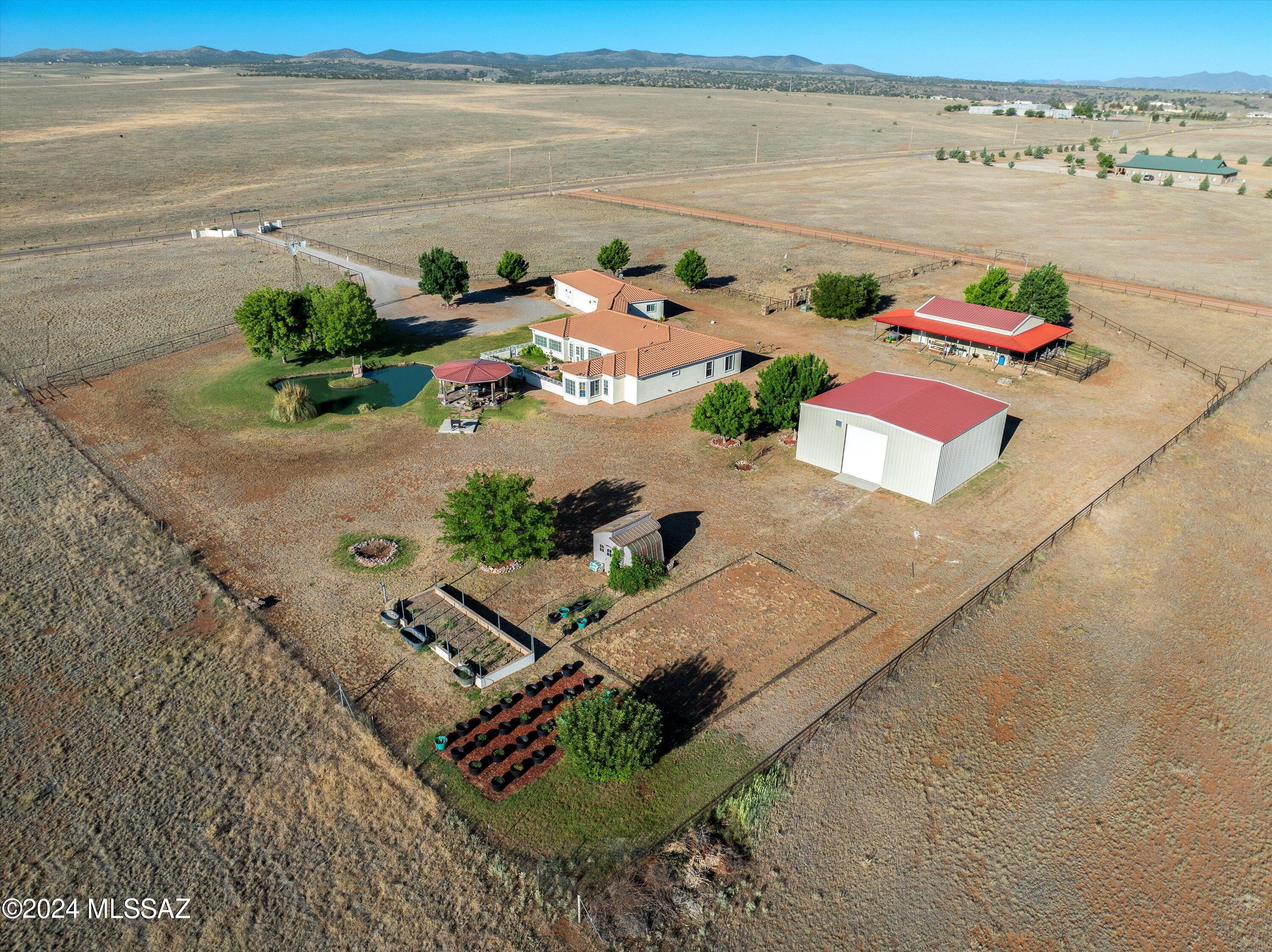 Welcome to an absolutely stunning property located on Winery Row in the heart of Southern Arizona Wine Country! This magnificent estate spans over 10 acres, with an option to purchase an additional neighboring 10 acres! The property features a beautifully updated 3-bedroom, 2-bathroom home with high ceilings, a charming 1-bedroom guest house, and a spacious 3-car garage. Car and RV enthusiasts will appreciate the free-standing, over-sized garage/steel shop building with abundant second-floor storage, as well as an insulated office or hobby room, offering endless possibilities! Additionally, the estate includes a barn/workshop, which also offers a second-floor insulated office or hobby room, and comes equipped with two horse pens. Enjoy panoramic views, a serene pond stocked with fish and fed directly from the private well, and a delightful ramada. The property is fully fenced and gated, has a 500-gallon underground propane tank, and underground PVC direct water feed to the pens and pasture. Perfect for anyone looking for a forever, private residence, a dream winery, or beautiful horse property with panoramic mountain views! Don't miss this rare opportunity to own a piece of Southern Arizona's premier wine country! The neighboring 10 acres is available for purchase for an additional $200,000 and comes equipped with a newer private well and electricity at the lot line.