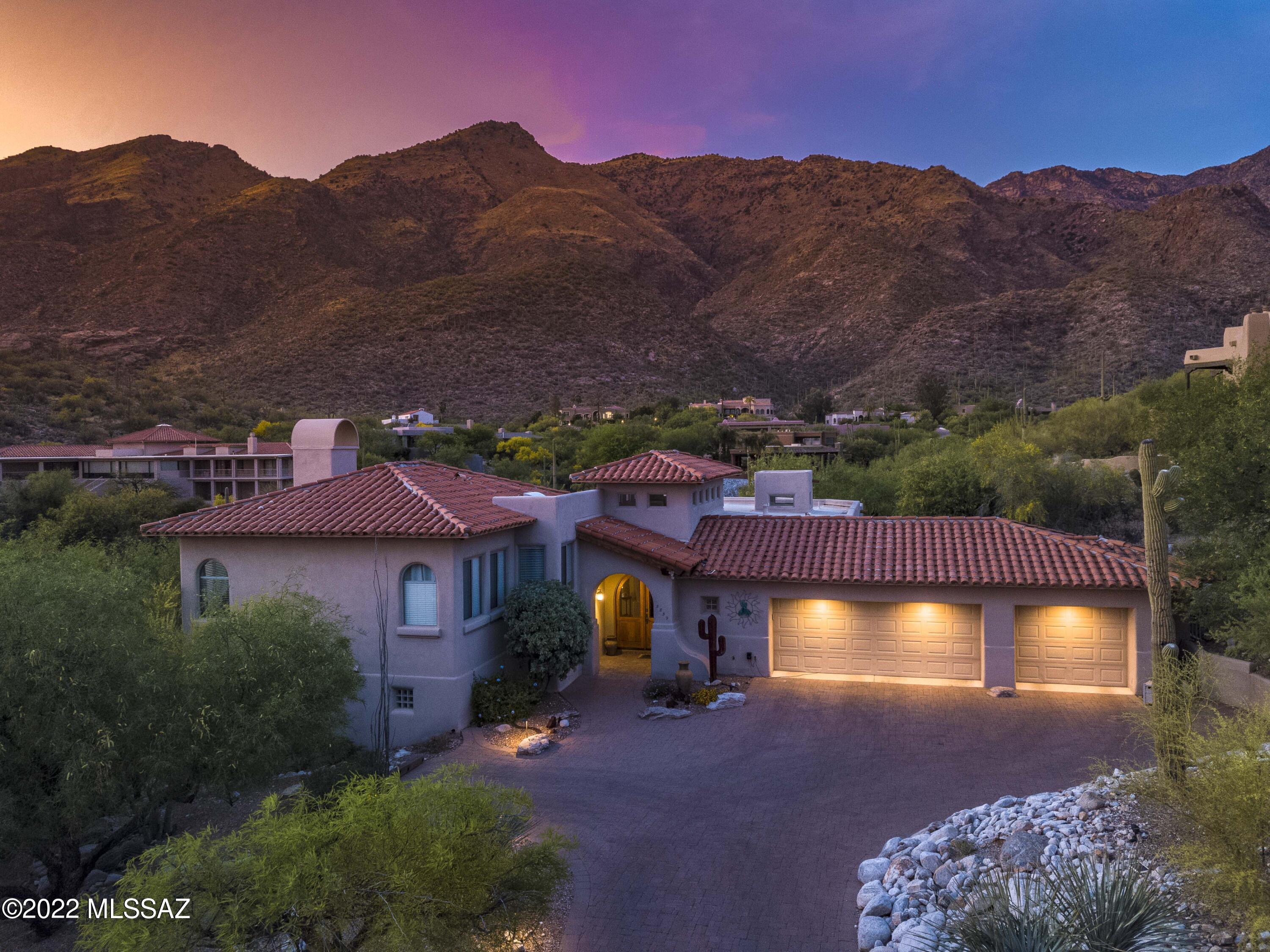 This exceptional four-bedroom/four-bathroom home is located on a premier 0.92-acre lot in the coveted Alta Vista Estates subdivision and features captivating views of both the surrounding Catalina mountains and the Tucson cityscape! The immaculate interior boasts exposed wood columns, an open floor living room off the entryway, a formal dining area, a cozy family room with mountain views and a gas fireplace, glazed maple cabinets throughout, a grand master bedroom with double-sided fireplace, dual vanities, spa style tub, walk-in shower, spacious walk-in closet, and custom tile work! The large, updated kitchen features premier stainless-steel appliances, granite countertops, a kitchen island with a gas stovetop, breakfast bar, desk, and an ample breakfast area. This home...see more..... ...also includes plenty of storage, including a large laundry room with cabinets and utility sink, and an extended three car garage. Exterior features include beautiful Spanish clay tile roofing, brick paver driveway, covered front entryway, elongated back patio, gas firewall, spa with built-in waterfall feature, flagstone walkway, built-in barbecue area, wrought iron fencing, custom lighting, and established natural desert landscaping! Recently renovated to remove polybutylene piping and freshly painted exterior, this home highlights pride of ownership at its finest! Set in the award-winning Catalina Foothills School District, this remarkable property is near fine dining, upscale shopping, and premier golf courses!