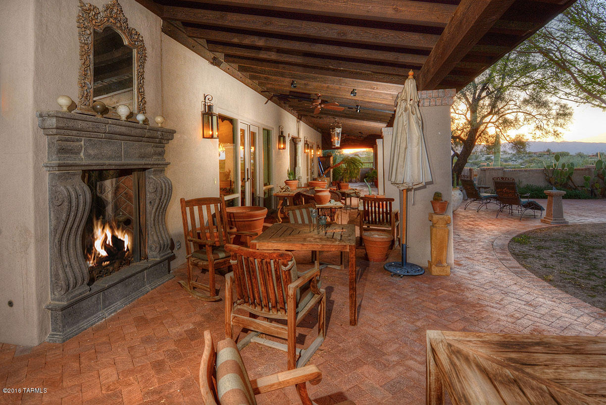 Classic Tucson territorial style hacienda high on a hill on a 1.61 acre lot in prestigious, gated, Catalina Foothills Estates #10 with sweeping Catalina Mountain views. With five bedrooms (den/library could be 5th bedroom) and 4879 sqft, this all masonry stucco home on one level with no interior steps offers rustic courtyard entry with brick pavers leading to foyer with soaring ceiling, beams, corbels and Saltillo tile floors. Spacious living room with fireplace, beams and Finger Rock views, formal dining room, expansive family room/kitchen with fireplace, entertainment wall, granite counters and gas ccoktop. Gracious master suite has viga beamed ceiling, fireplace and spa tub. Wonderful rear yard features expansive rear porch, fireplace, jet swim pool with fireplace.