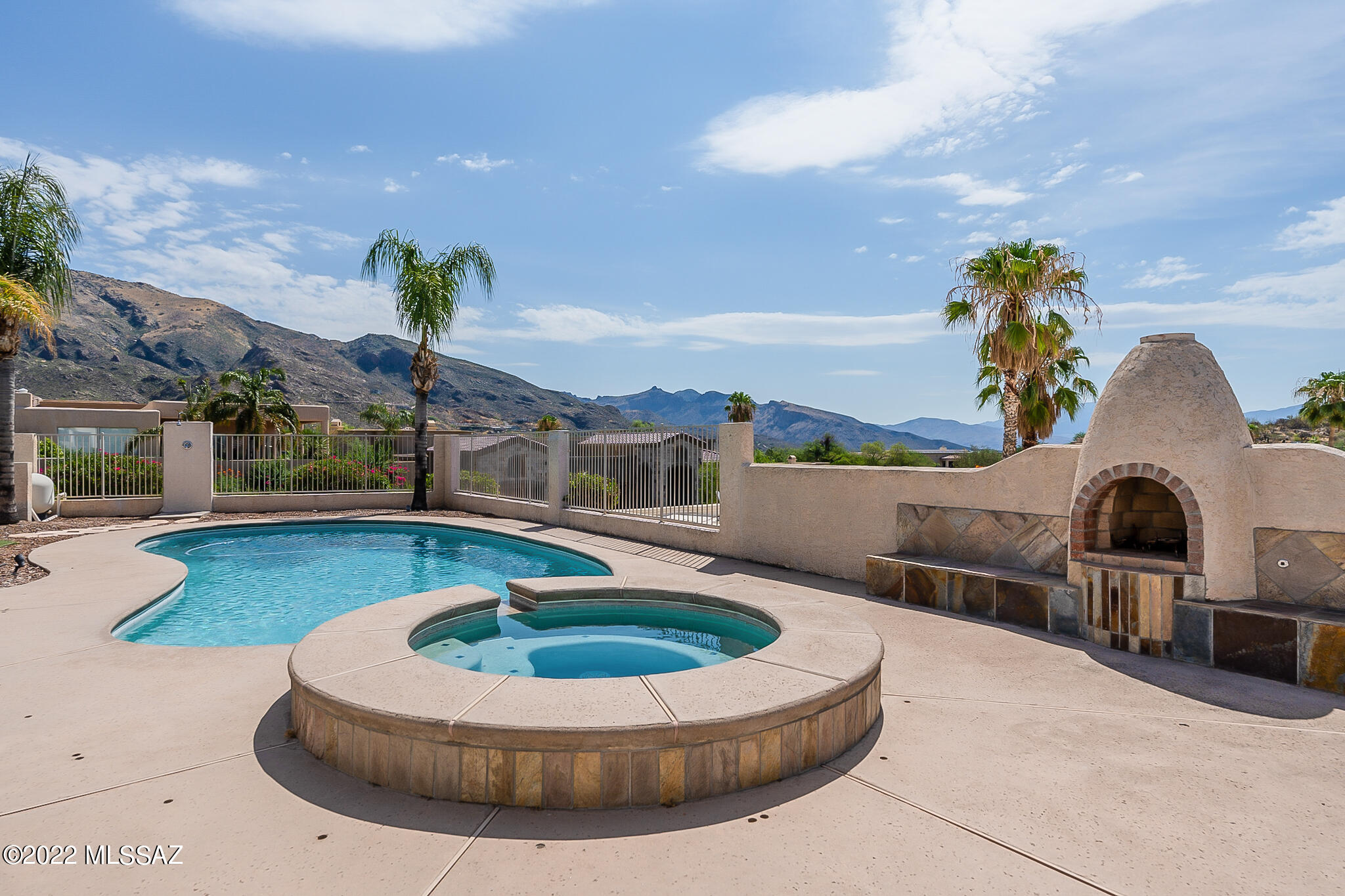 Perched on Premium Lot in Alta Vista w/ Sweeping Mountain & City Views. This Privately Gated Foothills Home Offers a Spacious Open Floor Plan w/ 5 Bedrooms & 3 Bathrooms. Fine Features Include: Living Room w/ Picture Windows & Wet Bar, Island Kitchen w/ Gas Cooktop Opening to Great Room w/ Walls of Windows, Motorized Exterior Shade Screens, Split Floor Plan, Master Suite w/ Fire Place, Walk in Closet & Spacious Bath w/ Dual Vanities, Shower and Jacuzzi Tub. Private Backyard w/ Palm Trees, Sparkling Pool & Spa, Covered Patio, Built-in BBQ, Beehive FP, Outdoor Shower. Front Yard Features Play Area w/ Play Equipment. Over-Sized 3 car garage w/ Storage Closet. Catalina Foothills Schools.