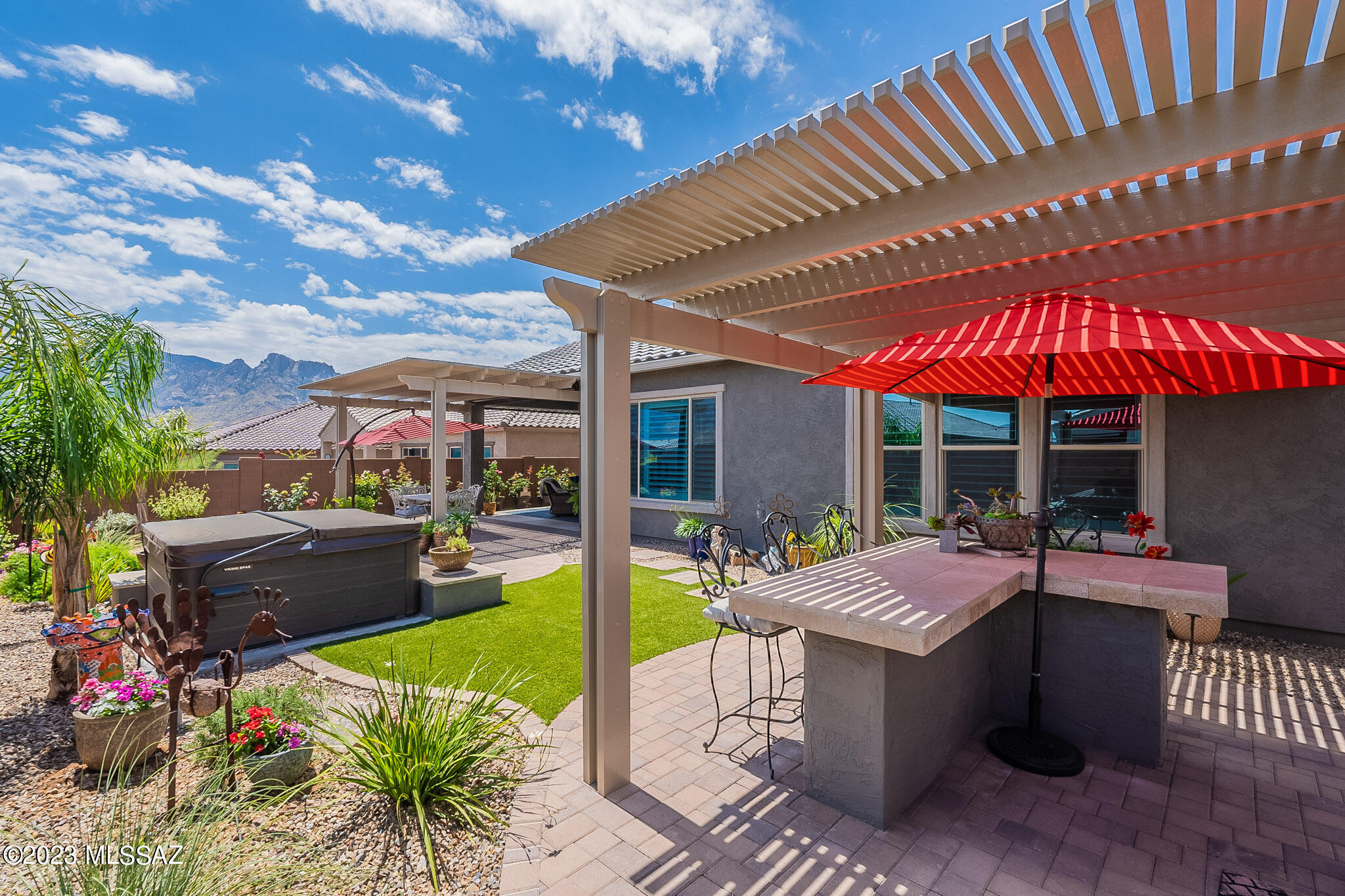 Nearly new 2021 VICENZA floor plan with beautifully landscaped backyard retreat. Enjoy mountain views from the hot tub, grill and gathering areas - covered patio w/extended ramada and pavers. Three bedroom + den, 2 1/2 bath home; owner's suite has large walk-in shower and closet. Split bedroom model with two bedrooms and bathroom on other side of great room. Large open kitchen with island, granite, stainless appliances and plenty of cabinets. Walk-in pantry adds storage. Gather at the bar counter or enjoy dining with mountain views. Home is wired for alarm system, audio, and ceiling fans. Extended 2-car garage with overhead storage provides room for bikes and other toys! Laundry includes sink and extra refrigerator. Fabulous location just minutes from groceries, gas and restaurants.
