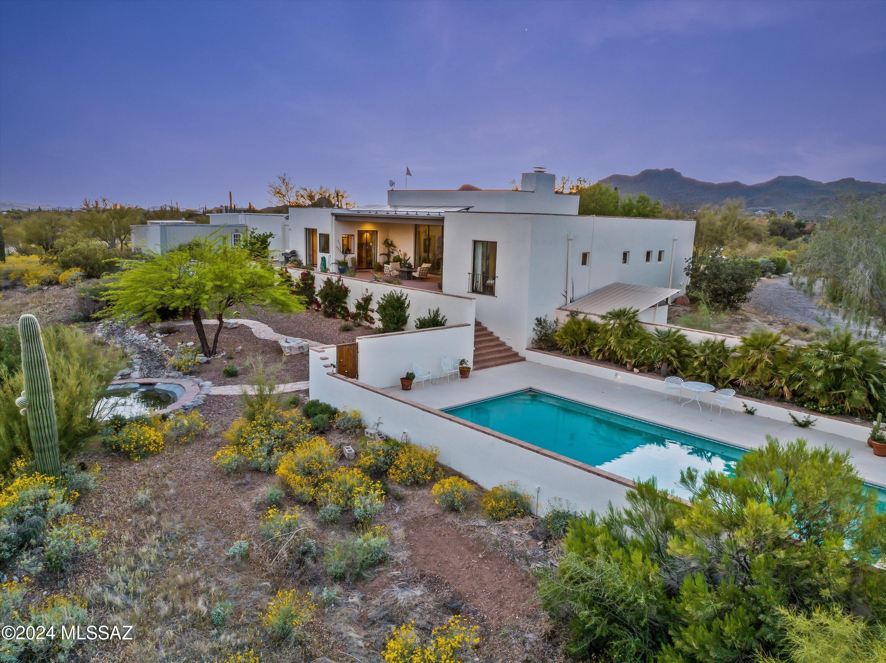 **PRICELESS VIEWS at this Stunning Estate in La Cholla Airpark: 8.7 Acres of Rustic Luxury with Hangar, Guest Houses, and Spectacular Mountain Views**

Nestled in the prestigious La Cholla Airpark, this expansive Saguaro studded 8.7-acre property offers an unparalleled lifestyle for aviation enthusiasts, horse lovers, and those seeking panoramic desert beauty. The estate features a spacious home, complete with a private hangar, horse stable starter kit, two guest houses, and resort-style pool set against the backdrop of the Tortalita Mountains with sweeping vistas of the Santa Catalina Mountains and city lights of Tucson. Reimagine this estate to meet your needs as it lends space for multigenerational living, a nature lover's retreat, or an entertainer's paradise. 

.... **Main Residence:**
The main home is thoughtfully designed to take full advantage of the surrounding natural beauty. Floor to ceiling sliding doors and windows create open spaces for a seamless connection between the interior and the outdoors, inviting the stunning mountain views and desert landscapes inside. Spacious living areas are perfect for entertaining, with high ceilings, wood beams and an abundance of natural light. The home boasts three en suite bedrooms, each with uniquely spectacular views and private entrances offering ample space and comfort for family and guests.

**Hangar & Aviation Access:**
For aviation enthusiasts, the property includes a private hangar, offering direct access to La Cholla Airpark's runway, amenities, and the convenience of taking off and landing from your backyard. 

**Horse Stable Starter Kit:**
For equestrian lovers, the property features a horse stable starter kit, providing the perfect foundation for your equine companions. There's plenty of room for additional improvements and customizing, with nearly 9 acres of land offering endless possibilities for horse facilities or riding trails.

**2 Guest Houses:**
Not one but two charming guest houses. Primary guest house connected to pool area, offers is own stunning views of wildlife along with privacy and comfort for visiting family or friends. Complete with its own living space, kitchenette, bedroom, and 2 private patios, this self-contained unit makes for a perfect retreat. A second bonus guest house near the hangar and horse stables offers addition lodging for staff, family, or guests. 

**Outdoor Oasis:**
Outside, the resort-style pool invites relaxation and enjoyment, while the expansive outdoor living areas provide a perfect setting for hosting gatherings or enjoying the quiet sanctuary of the desert beauty and wildlife. A Spanish style fountain in the front and flowing stream to a pond in the back along with mature native trees brings coolness and tranquility to this desert oasis.

**Unrivaled Views:**
With 360 mountain views of this property is unparalleled with the Tortalita Mountains to the north , the Santa Catalina Mountains to the south, and the Tucson valley lights below. Whether you're enjoying a quiet sunrise or an evening sunset, these views are truly awe-inspiring and provide the perfect backdrop for entertaining or everyday living in your new home.

This exceptional estate in La Cholla Airpark combines the best of both worlds: the serenity of rural living with the convenience of aviation access, stunning views, and room to roam. Just 10 minutes from shopping and 30 minutes from downtown. Don't miss the opportunity to own this one-of-a-kind property!