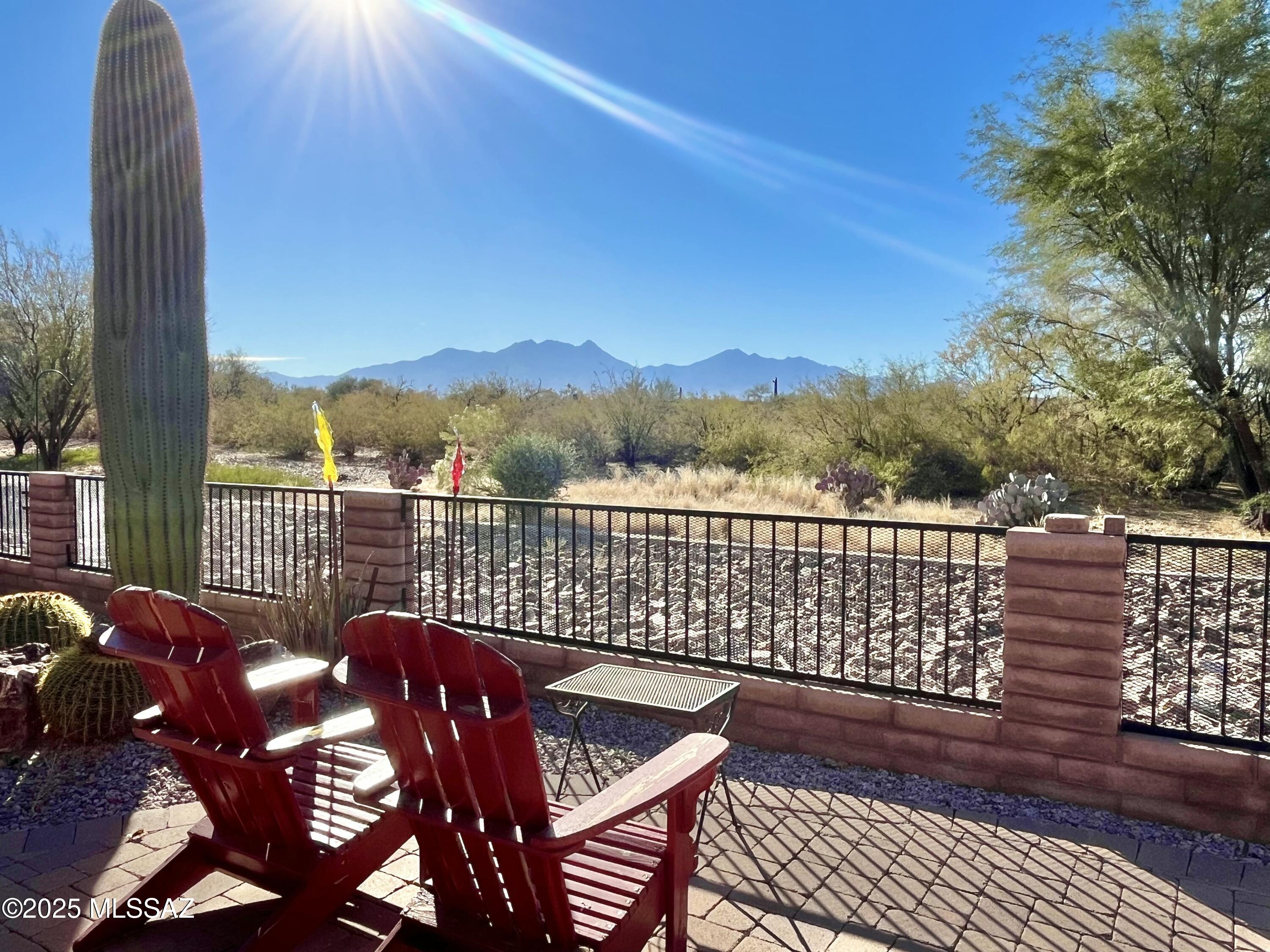 Amazing views of the Santa Rita Mountains and double wash behind this home! Main house offers 2-bedrooms plus den and 2.5 baths. Casita offers kitchenette, bathroom, and 6' slider to the courtyard. The fully walled yard comes with hot tub, fire pit, built-in BBQ, and remote controlled solar screens. 2.5 car garage is extended 4' with epoxy floors and an electric car charger included. Italian tile floors throughout, ceiling fans, Hunter Douglas window coverings. Chef kitchen layout incorporates cherry wood cabinets with platinum grade granite counters, induction cooktop w/ gas option, warming drawer, wine fridge, under cab lighting, and pull-outs. Fridge, washer, dryer included. Primary includes closet organizer and enclosed shower with dual heads. Guest room has en-suite bathroom. Den Den includes built-ins and a 6' slider to the front courtyard. Coffered ceilings and built-in entertainment center in great room. Water Tea filtration system. This home offers so much!