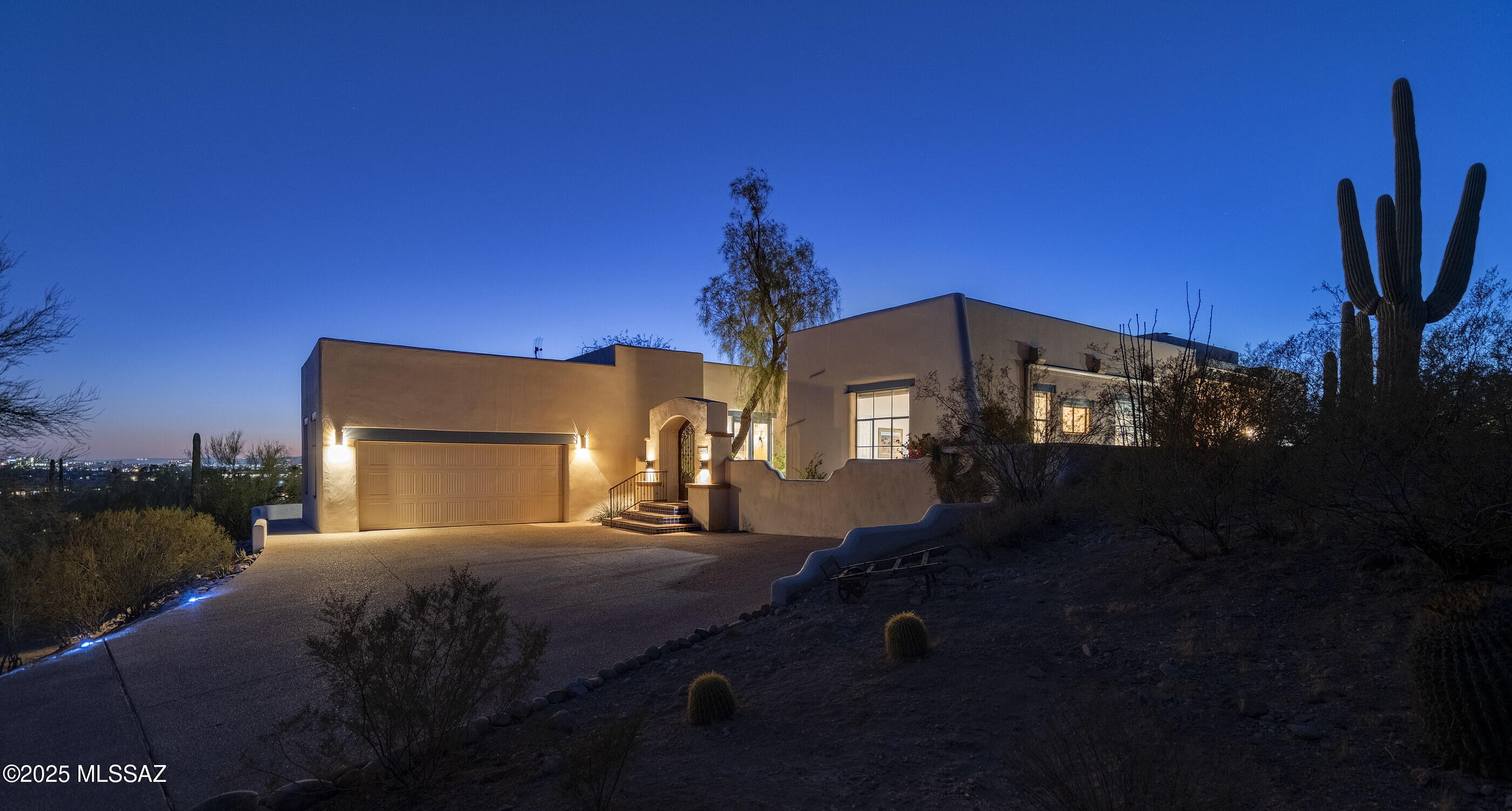 Nestled within 2.11 acres of the untamed Sonoran Desert, this residence stands as a dialogue between architecture and landscape. Designed by Marc Gerson and built with precision by Jed Paradies on one of the most sought after streets in ''The Foothills,'' while offering panoramic views that frame the raw beauty of Finger Rock and the Catalina Mountains to the north. To the south, the distant Santa Rita Mountains, the University of Arizona, and the ephemeral glow of A Mountain's Fourth of July fireworks anchor the horizon. Upon arrival, a sculptural gate opens to reveal the first of five patios. These outdoor spaces extend the interior into the surrounding desert, each positioned with intentionality. Two patios adjoin the primary bedroom, while others flow from the living room and dining areas, culminating in an interaction with the newly re-plastered pool and spa- a serene reflection of the Arizona sky. Through nine skylights, sixteen expansive glass doorways, and meticulously placed windows, light moves effortlessly through the home, creating a rhythm of brightness and shadow while maintaining a sense of privacy.

A temperature-controlled wine cellar, calibrated for 675 bottles, and paired with a concealed beverage center featuring refrigerated drawers, offer refined solutions for curated living. Each of the four bedrooms, with walk-in closets and en-suite baths, serves as a sanctuary. The tranquil sound of water, both from the pool's edge and a fountain near the living room, layers a sensory dimension to the environment, transforming the home into a retreat, while being within mere moments from La Encantada and the conveniences of Campbell Avenue, yet grounded within the desert's vastness.

The kitchen is an exercise in precision and quiet luxury. Appliances by Wolf, Monogram, and Bosch integrate seamlessly into millwork crafted by Canyon Cabinetry, while the gas range's roof-mounted ventilation whispers its function into the background. The thoughtful composition of materials extends to the fireplaces in the great room, living room, and primary bedroomeach a nucleus of warmth and intimacy within the home's spatial hierarchy.

In the living room, where scaled wooden ceilings soar, and unique lighting fixtures establish a sculptural presence. Spotlights gently enhance the home's curated art, while under-cabinet illumination in the kitchen and beverage center creates a soft, inviting glow. Outside, lighting along the patios blends function and form, guiding residents and guests with an understated elegance.

The landscaping merges seamlessly with the architectural language, celebrating the native beauty of the Sonoran Desert. Chilean mesquite, desert museum palo verde, and succulents stand alongside vivid blooms of bougainvillea and Mexican bird of paradise, attracting hummingbirds and butterflies alike. Anchoring the composition is a young Chinese pistache tree, its eventual stature promising shade and seasonal transformation. Two irrigation systems balance the natural austerity of the desert with the home's cultivated grace. This is not merely a residence; it is an environment, a convergence of light, material, and space that invites contemplation and harmony.