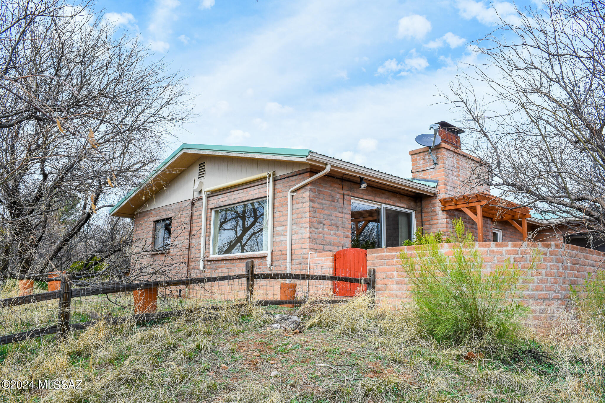 Nestled in the hills of Patagonia, sits this sturdy, well-constructed, slump block home on 2.7 acres consisting of multiple town lots. This cozy ranch home inclds attach garage, metal roof, built-ins, gas Wells fireplace & 2 enclosed side yards w/ a soothing pond that attracts wildlife such as fox, deer & birds. Completely fenced w/ 2 access drives. Surrounded by mesquite trees & native plants providing the right amount of privacy & natural beauty. Relax under the cov'd front porch or enjoy the INCREDIBLE views of the Red Mtns & front row seats to the annual 4th of July fireworks from your enclosed back patio! Conveniently located w/in walking distance to local amenities including shops, restaurants, trails, park & high school. This gem is ideal for the savvy Investor, a must see!