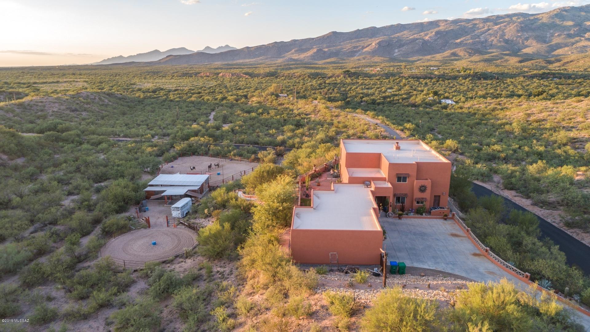 Beautiful Rincon Valley custom Sante Fe,horse property,paved rd. & BREATHTAKING VIEWS! Step inside to soaring ceilings,natural lighting,tile flooring & custom color tones.Open space with a formal living/dining area,off the kitchen is the family room w/cozy fireplace & ample entertaining space.Custom wood cabinetry, S.S.appliances, dual sink, large island/breakfast bar & walk-in pantry.Escape to the spacious 1st floor master suite w/ amazing mountain views,fireplace,walk-in closet, jetted tub w/views of Rincon Peak. 2nd floor w/ additional family room & walk out balcony w/ unobstructed views for miles. Entertain friends & family in your stunning back yard with above ground spa & fire-pit,perfect for chilly evenings.Lighted stairway to the horse facilities below,mins to trails.See 3D video Facilities include 60 foot round pen,laser leveled arena, 20 x 40 covered stall area,covered wash rack, electric and water. Access to trails, and riding distance into Saguaro National Park.Roof coated in April 2018 with 2 year warranty, termite treatment December 2018 with 5 yr transferable warranty,whole house water filtration system installed February 2018.New HVAC IN 2017 with 10 yr parts warranty, new dual pane windows with lifetime warranty installed in 2017.