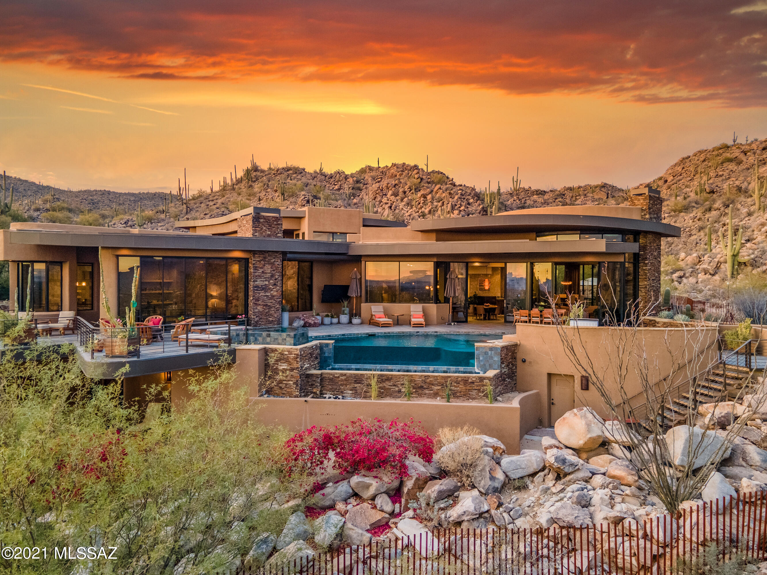 Be ready to be swept off your feet from the  moment you walk into this hilltop estate. Be enamored by its curves and captivated by the carefully selected finishes by Lori Carroll. From the rarely seen granite selections to the small details such as cabinet and drawer pulls that are all works of art. You will not be disappointed by the quality luxurious materials that went into this home.  All furnishings convey with the home which were also selected by Lori.  Carefully laid out Guest Quarters with 2 Bedrooms 2 Ensuite bathrooms, full kitchen, great room, dinette and pool table. Upper loft area can be used as 4th bedroom, Office, Theater Room, Exercise Room, etc. the possibilities are endless.  Walk out from this loft space onto a massive deck finished with turf putting green.  TV hook-up outdoor speakers, bar top tables and prep sink turn this space into a fully functioning party spot.  Elevator leads you to lower level (exterior). 3 Car Garage with large workshop, heated and cooled, built-in cabinets and bathroom. 
The best is yet to come when you step outside from Great Room and take in a view that goes on forever.  Mountains and City Lights so dramatic you will feel like you are in a movie scene.  Fire features, glass negative edge pool, fire pit and full outdoor kitchen complete with 2 beverage drawers, Viking BBQ and storage.  So much to see and experience.  Schedule a time to view this outstanding home. Sports Membership Required in this development. Stone Canyon continuously ranks in the top 100 Courses in the Country. Tour of the facilities can also be arranged.