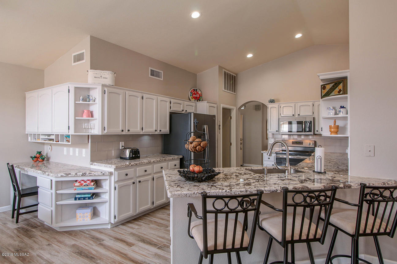 This elegant Topaz has been fully remodeled inside and out. Beautiful porcelain woodgrain tile flooring throughout with new carpet in bedrooms, new paint in and out,  all new kitchen appliances, rear screened in patio (newly sealed patio roof), New AC, new terraced backyard patio with mountain views. The bathrooms are all updated with granite countertops. New irrigation system installed in backyard. This home is priced to sell and is ready to move in. You will be proud to own this modern updated home just blocks to all amenities.  SaddleBrooke is a premier active adult community with hundreds of clubs and an amazing amount of amenities. This will go fast, come see our open house!!