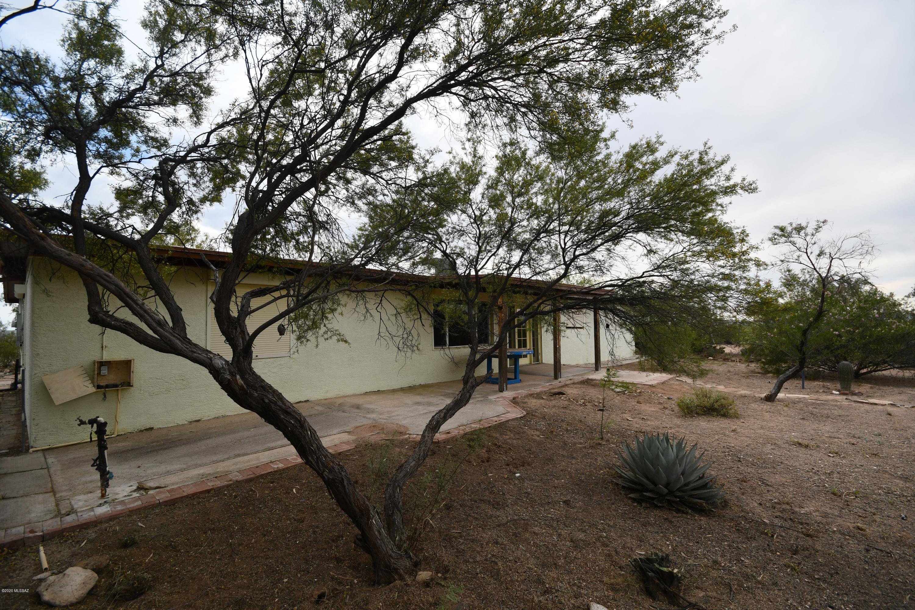 Unique opportunity for charming ranch house situated nicely on a 2.5 acre homesite. Zoning is GR1 which allows one home per acre. Massive rock fireplace in the living room, wood beam ceilings, Saltillo tile. Huge bonus/family room perfect for pool table, home office or potential for guest quarters. Massive island country kitchen with granite counters and tons of cabinet space storage. Security shutters make this a perfect snowbird residence, just lock up tight when you leave. Garage is detached 4 car tandem with two car carport. Additional acreage available.