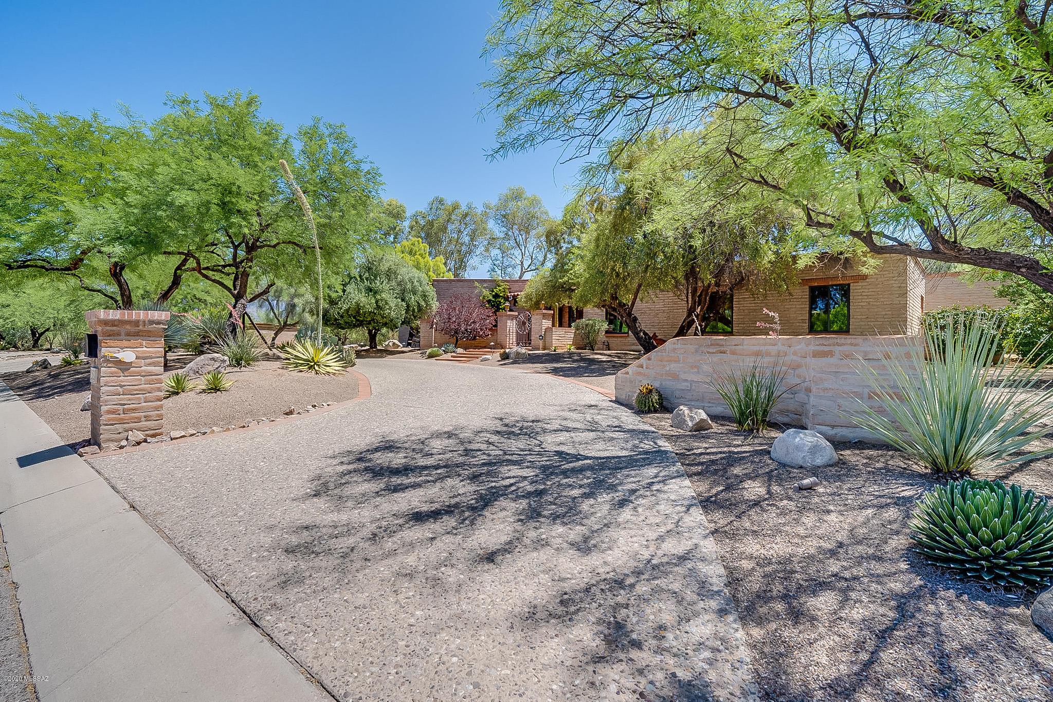 Enjoy the Tucson Country Club lifestyle in this sprawling burnt adobe home situated on stunning lot with mountain views and mature trees in sought after gated neighborhood. Immaculately maintained with upgrades throughout. The interior reflects an Old-World style mixing warmth with formality in an easy flowing floor plan with high ceilings and tons of storage space. Enjoy a kitchen complete with upgraded appliances, custom cabinets and beautiful granite countertops. The master suite has a sitting space, luxurious spa bath, his and her walk-in closets and bonus room perfect for office/den. Two more spacious secondary bedrooms one with a darling window seat/study niche with exposed brick.  Backyard oasis has turf, large covered patio and lots of privacy There is ample closet space throughout. The backyard oasis has new turf, beautiful trees, large covered patio and privacy. Park your cars or golf cart in 3 car garage. Don't miss this opportunity to live in Tucson Country Club.