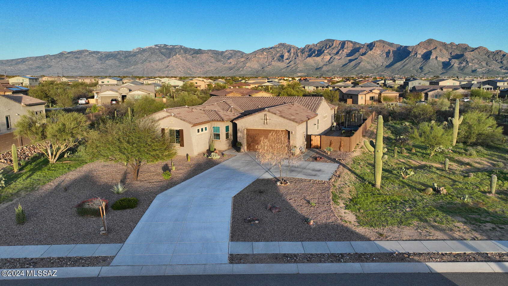 Spectacular Oro Valley home that sits on almost 3/4th of an acre in a gated community. This home built in 2020 has 4 bedrooms, 2.5 baths, an office and a den. Walk into the welcoming great room where you will be introduced to the captivating Catalina Mountain view, large great room that can entertain a large gathering or cozy up to the fire for a quaint quiet evening. Bring the outside in with the double sliders that lead you to the sparkling pool and spa.  The home has been built with a extended length garage for ample space and is equipped with an electric charging station. Don't let this one get away!