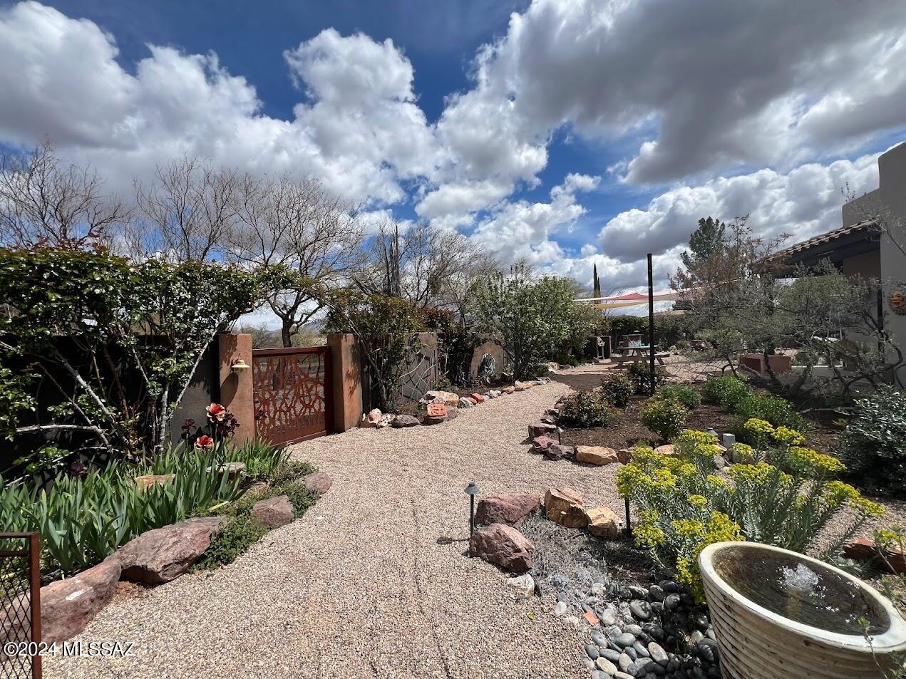 A true oasis in the Tubac Valley and private near the Tubac Golf Resort with fabulous garden and swimming pool amenities. Providing year-round plants for nesting, food and water, this old world rose garden became a bird watchers paradise. Private gated drive entrance, 600 Linear feet of a masonry wall surrounding the home with numerous incredible areas with specialty gardens, fruit trees, food garden, fountains and much more. Put your feet up and enjoy native and migrating birds in the privacy of your yard! Old world rose varietals provide fragrance and color interest, bubbling water fountain for sound and birds. All landscape irrigation and lighting are on automatic controllers. This yard has been designed & built for indoor out living. See the possibilities for your perfect lifestyle! Raised vegetable gardens provide year-round harvest along with fruit and nut trees.  The pool is plumbed and ready for solar connections as well. A concrete pad awaits the possibility of a future screened porch, a space for a future pool house and utility ready outdoor kitchen. Numerous energy efficient upgrades. Construction: 2 1/2 exterior/Interior walls separated by 6 poured concrete rated R38 insulation, Trane unit w/2 speed motor more efficient cooling & gas heating. Anderson windows casement type, low E glass, 3 ply built-up roof w/ base sheet & final reflective layer, insulation above duct work for energy conservation. Other upgrades include gas Fireplace, custom cabinets, stainless H2O softener, Artist room, den, study, large laundry room, new large water heater, large pantry off kitchen, hardwood doors throughout.
