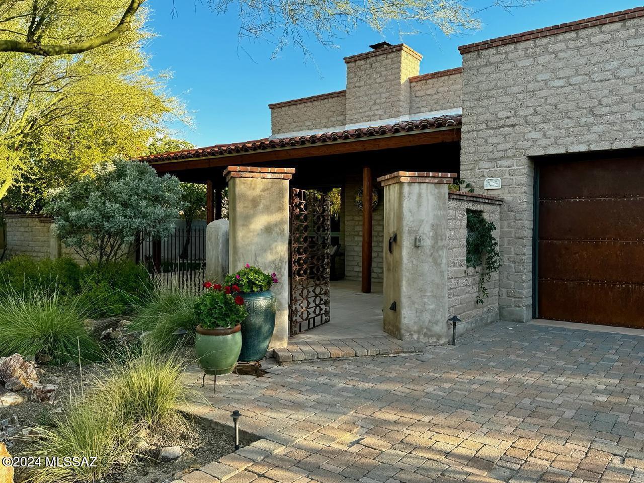 This home is custom built by James Gray of Steller Gray, a Tucson area premier designer and  builder of Territorial style homes.  This home is located in The Adobes section of 26 homes within Skyranch, each home is placed on large lots surrounded  by hundreds of acres of a protected natural preserve.  The home itself is a unique blend of Pueblo and Territorial architecture combined to form a unique style, a throw-back to the 1800's, with bold wood posts, portals, roof-top brick trim on parapet walls, smooth interior artisan plaster offset by onsite produced mud adobe walls, solid alder 1.75'' interior doors, custom wood windows with metal clad exterior, massive interior hand hewn wood beams.  Heavy steel exterior doors frame the entrances that add to the old world charm.