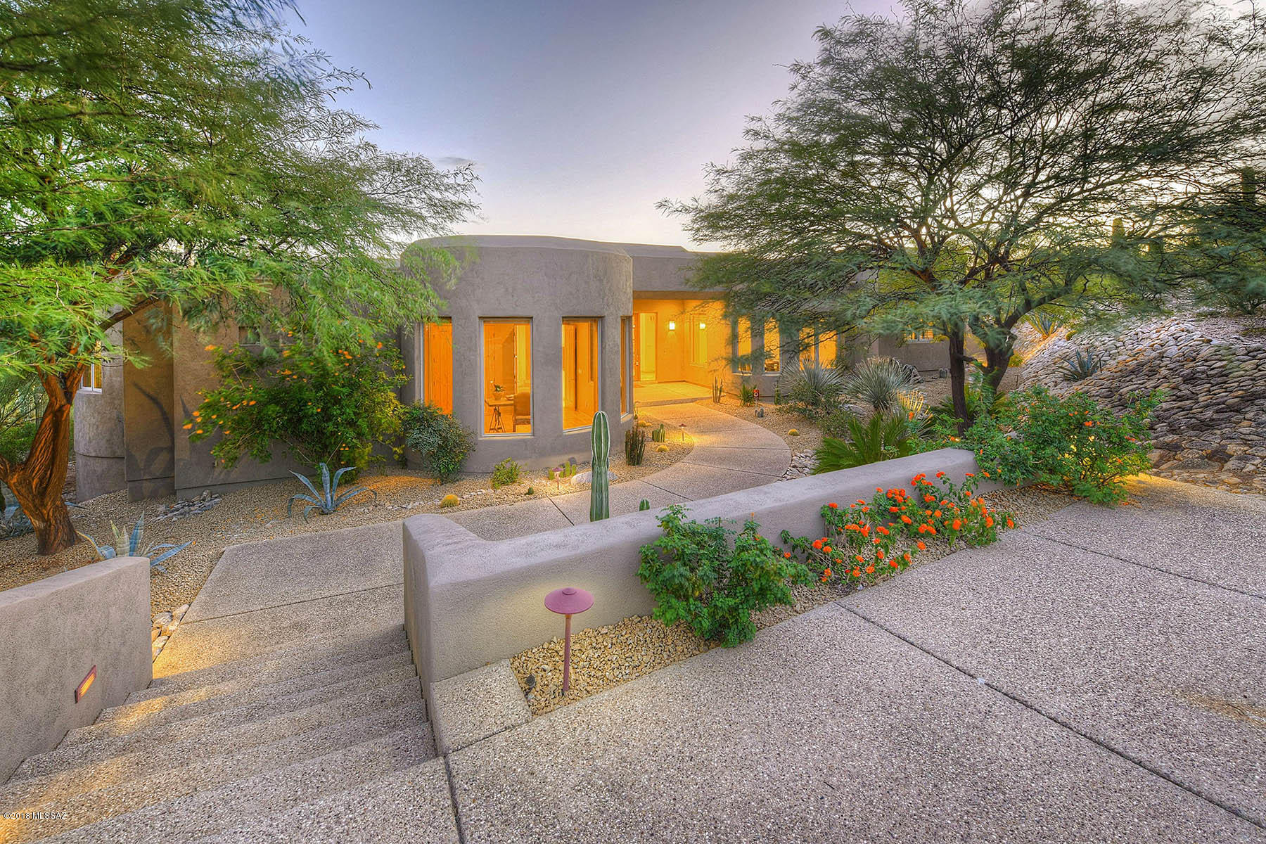 Feel the peace, quiet and seclusion of a country setting with the amenities of the city just minutes away. This soft contemporary features high ceilings, 8-ft solid mesquite doors throughout, travertine floors and has been crafted with quality and remarkable attention to detail. The views are spectacular with the Catalina Mountains on one side and views of the city on the other. Relax with gorgeous pool, with water features, jacuzzi spa. Outdoor entertainment area with fireplace, 2 grills, refrigerator and sumptuous views.
