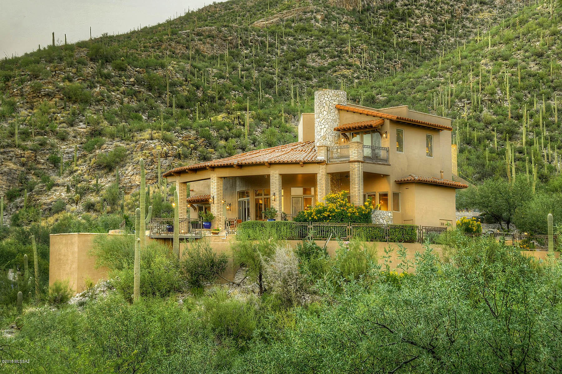 Situated high above Ventana Canyon's famous 3rd hole sits this gorgeous 5,039 sq ft home with sweeping 180 degree sparkling city lights, mountain & colorful sunset views. Only a few minutes away from the popular club house. High end finishes include, alder doors, beautiful mesquite flooring though out & stunning stone fireplaces. Gourmet kitchen looking out into the great room offers granite island with cook- top, stainless appliances & walk-in pantry. Bottom of spiral stairs case  showcases beautiful wine room. Luxurious master suite, spacious upstairs family room, guest bedrooms with jack & jill bathroom, plus guest quarters for guest or nanny located off the 3 car garage with golf cart space. Fabulous outdoor space with pool, spa & grassy play area.