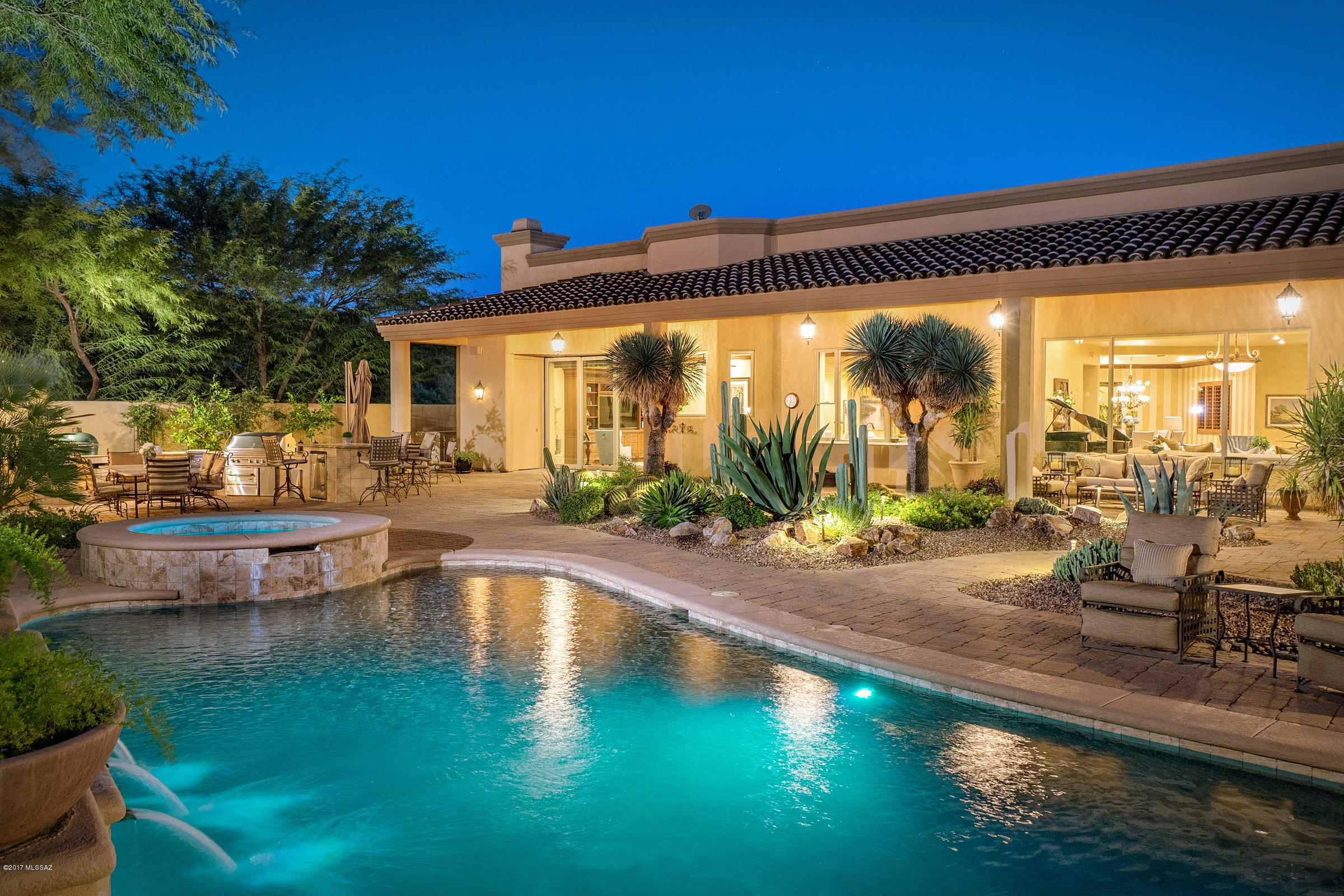 Fully remodeled, custom-designed and built, this incomparable residence is located behind private gates, up a long secluded drive, to this sophisticated estate.Surrounded by sprawling and mature desert landscape, an air of grandeur pervades this 6,430 sq. ft residence, with welcoming tones & textures, adding a sense of warmth and depth to the space. The heart of the home is the fabulous chef’s kitchen with gorgeous custom finishes throughout and family room, with a fireplace, breakfast area, adjoining the hand crafted bar, exuding elegance with carved wood cabinetry & marble countertops. The main, light-filled foyer opens onto the sophisticated formal living & dining rooms, featuring cove ceilings & gorgeous wood molding, with awe-inspiring views of the Catalina Mountains.