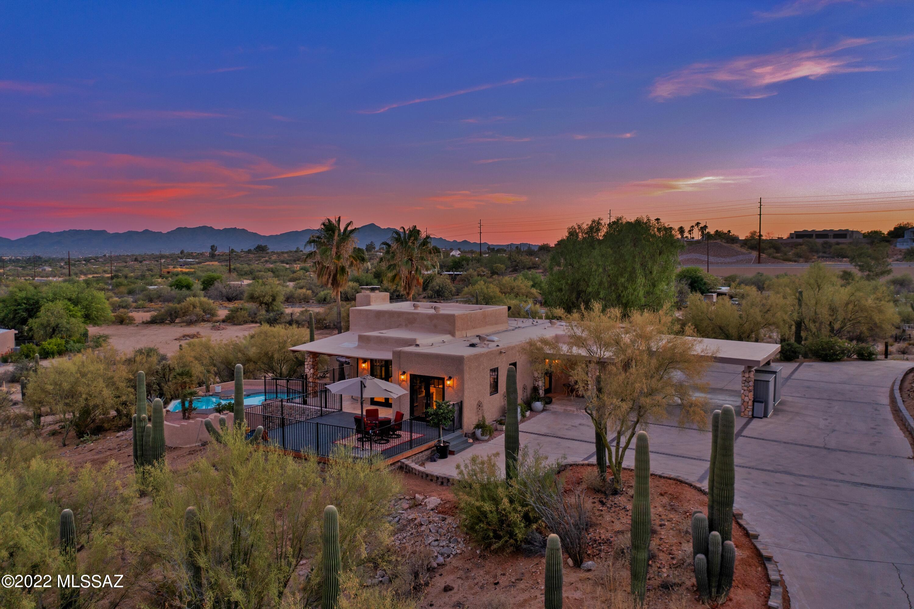 Custom built hilltop home in Oro Valley on 3.4 acres with breath taking views of the Catalina Mountains, city lights and beyond. Main level is an open floor plan with views from every window and door with a private den and balcony. Stunning contemporary design with rich and bold finishes, souring beamed ceilings, natural stone floors, Anderson doors and windows, custom stone cut light fixtures and fully equipped custom chef's kitchen complete with a separate Beverage center and built in Miele Cofffee System. Just off the foyer is a powder room and the master wing with private bath, dual vanities separate shower and standalone bath tub. Downstairs has direct access to the pool  area and garage perfect for the kids or guests with  a kitchen, two bedrooms, one full bath and a bonus room.