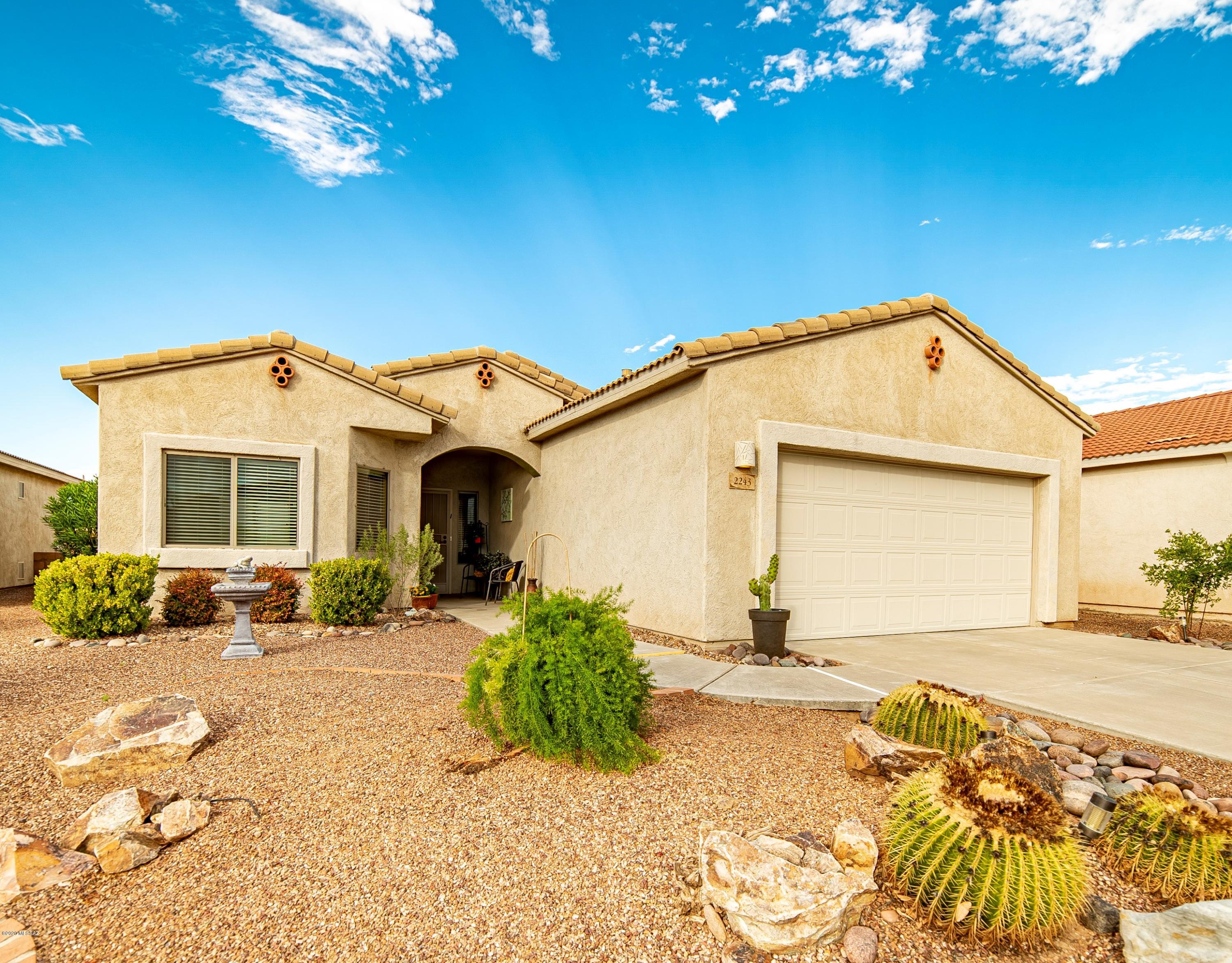 If you're looking for great privacy and a larger yard to call you own then be sure to put this beautiful home at the home of your list!   Here is your opportunity to claim the rare Holiday plan with 1798 square feet and 3 spacious bedrooms.  This open floor plan has 10 feet ceilings and combines architectural angles with arched doorways and niches to add interest.  Warm tone tile flooring and custom paint colors emphasize that you are living in the southwest.  A serving island leads you into the country kitchen where attractive glass front cabinetry showcase your favorite serving pieces.  Your primary bedroom suite has a spacious bath with espresso tone executive height dual sink vanity with striking lighting fixtures.  With 2 guest bedrooms and an additional room to use as either formal dining or an office, you'll have numerous options to fit your lifestyle.   Wonderful outdoor living spaces - relax on the extended covered back patio with its mature Chaste tree swaying in the breeze, desert gardens, crisp landscaping and flowing river rock setting the stage for peace and tranquility while enjoying mountain views.