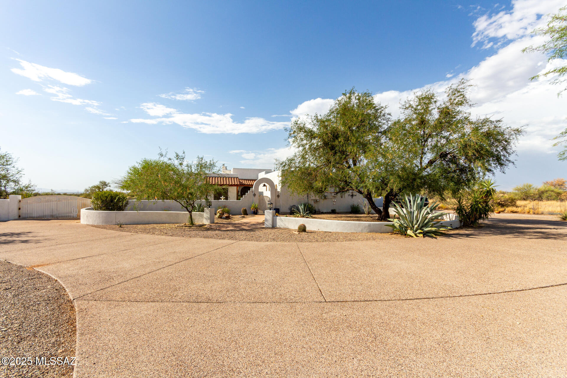 Fabulous custom-built hacienda. This true Sante Fe style home on over 4 acres and 3228 sq.ft. in a gated community. Features hand-made solid wood alder doors and windows, high ceilings with over 100 Vega beams inside and out (imported from Santa Fe) Custom work including lovely Talavera tile sinks, showers, and countertops. Polished scored concrete floors all through out. All bedrooms have own bath and shower. Big master bedroom and walk-in closet with lovely ceiling fans throughout. Over 1900 sq.ft. of vega-beam wrap-around patios, outdoor fireplace, wonderful, heated pool and spa area all within a large walled-in back yard. As you drive up into your full circular driveway you will enter through the front gate to see the lovely front courtyard with fountain. Total privacy and 360 degree views await you at the end of the road.