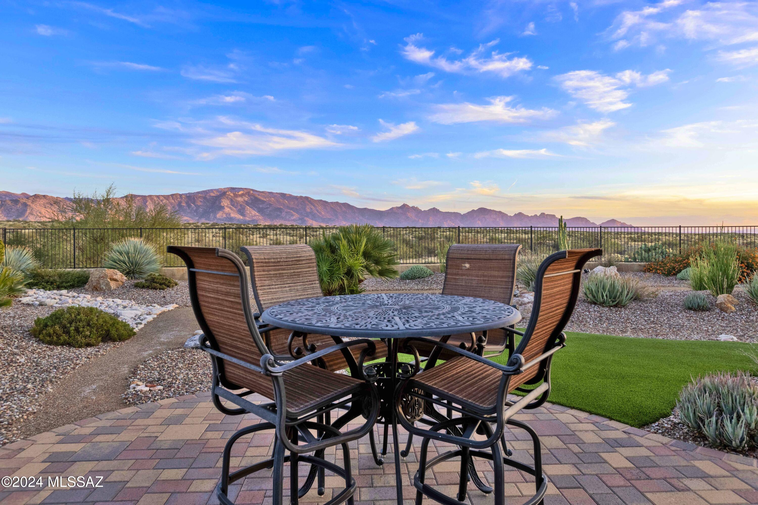 Welcome to a serene haven w/breathtaking panoramic mountain views & privacy. Set on one of the best premier lots, this exquisite Tesoro, with all available architectural room extensions, features premium knotty alder wood cabinets, a gourmet kitchen equipped w/gas cooktop, luxury brand range hood, pendant lights, & more. A bar/buffet as well as a Butler & a Walk-in pantry makes entertaining easy. The deluxe primary suite boasts a curbless shower & custom walk-in closet.  Large bedroom creates a perfect retreat. Outside the paver patio extension offers addtl space to savor the stunning mountain views. Large covered patio has rolling shades & a cozy fireplace, ensuring comfort & enjoyment year-round.  Discover the perfect blend of luxury and tranquility in this meticulously designed home.