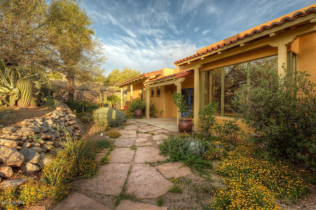 Total Charm and Character in a Beautiful Private Setting with Panoramic Mountain Views. 542 SqFt Guest House built in 2000. Lush Courtyard Entry. Gourmet Kitchen with Granite and Butcher Block Island. Living Room with high Beamed & Planked Ceiling, Beehive FP and Window Seat. Separate Family Room. Split Bedroom plan with Private Master Suite. Main House has 3 Bedrooms/ 3 Baths. Second Large Bedroom with Private Bath.  Bonus Room could be Office, Gym. Remodeled and Lovingly Maintained. This Hacienda is Tucson Living at it's Best!