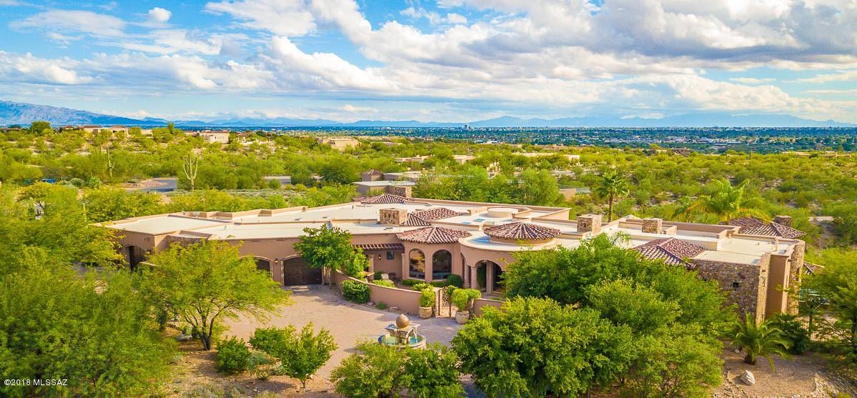 PREMIER FOOTHILLS PROPERTY! TUSCANY INSPIRED, GREG SIMMONS DESIGNED CUSTOM HOME W/ 13,400 SQ FT UNDER ROOF! SPRAWLING 2.84 ACRE COMPOUND IN GUARD-GATED CATALINA FOOTHILLS ESTATES #10. UNIQUE AND LUXURIOUS MAIN HOUSE W/ ELEGANT FINISHES THROUGHOUT. EVERY ROOM A SHOWPIECE  W/ UNIQUE DESIGN ELEMENTS. INCREDIBLE DISPLAY OF WOOD AND STONE CRAFTSMANSHIP. CHEFS KITCHEN W/ 2 LARGE ISLANDS, SUBZERO, WOLF & VIKING APPLIANCES. GORGEOUS FOYER, FUN BAR/BILLIARDS ROOM, OFFICE, EXERCISE ROOM & DETACHED GUEST HOUSE. RESORT QUALITY BACKYARD W/ GORGEOUS POOL & SPA AREA W/ SWIM UP BAR. LARGE GRASS AREA, PUTTING GREEN & BASKETBALL COURT. RECENT $150,000 INVESTMENT PROVIDING STATE- OF-THE-ART ENTERTAINMENT, SECURITY & LIGHTING SYSTEM. 6 FIREPLACES, SEVERAL COURTYARDS & FOUNTAINS &...A MOAT. FLOORPLAN ATTACHED.