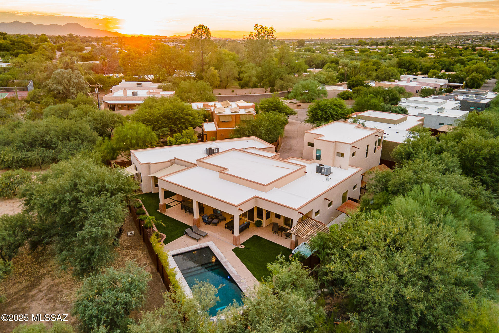 Hidden within the prestigious Old Fort Lowell neighborhood, this architecturally stunning sanctuary offers the perfect blend of modern luxury and serene privacy. Tucked away in an exclusive gated community of just five homes, this exceptional property is nearly invisible from view, accessed through a discreet patinaed metal gate. Designed in 2019 by acclaimed Tucson architect Timothy F. Robertson, this one-of-a-kind residence masterfully integrates contemporary design with lush surroundings, creating a seamless indoor-outdoor living experience.Despite its central midtown location, moments from Tucson's finest dining, shopping, and cultural attractions, this home is a peaceful escape, offering unparalleled tranquility.
As the developer's personal residence, it is positioned at the back of the enclave, ensuring the utmost privacy. This modern masterpiece embraces the philosophy that "less is more," delivering sophisticated simplicity and flexible living spaces designed for both grand entertaining and intimate daily life. The estate comprises: 1) A 3-bedroom, 3.5-bathroom primary home, each bedroom featuring an ensuite bath and well-appointed walk-in closet; 2) A private casita with a separate entrance, full living area, terrace, kitchenette, ensuite bath, and walk-in closet & 3) A stunning basement recreation room, designed for ultimate relaxation and entertainment.
Expansive glass walls and soaring ceilings flood the home with natural light, while neutral gray tones provide a canvas for dramatic artwork or colorful accents. The large-motif scored concrete flooring throughout the main level is both stylish and easy to maintain.
The heart of the home is a spectacular open-concept kitchen, living, and dining area, designed for effortless flow between spaces. Highlights include:
" A dramatic oversized island with seating for eight, storage
on all sides, and discreetly placed power strips for tech
convenience
" High-end stainless steel appliances, including a wine
refrigerator
" Sleek quartz countertops and custom cabinetry
" A linear fireplace, creating a warm, inviting atmosphere
" A full bath with outdoor access serves as both a guest
powder room and a convenient pool bath.
The primary suite is a luxurious retreat, featuring:
" Floor-to-ceiling glass doors opening directly to the pool, hot
tub, and mist-cooled terrace
" A spa-like bath with a Jacuzzi soaking tub, oversized walk-in
shower, and an expansive walk-in closet with custom built-
ins
Each additional spacious guest bedroom includes its own ensuite bath and walk-in closet.
Descending via a vibrant custom-designed Stark carpet runner, the basement-level recreation room is a show-stopping entertainment hub, complete with:
" A pool table (conveys if desired)
" Room for luxurious seating and a full bar area
" A large screen TV setup for movie nights and sports events
" An adjacent storage room for added convenience

Accessed via its own entrance, the attached casita is a fully functional living space, ideal for guests, multi-generational living, or an upscale home office. It boasts:
" A spacious living area with scenic views of the Catalina
Mountains
" A fully equipped kitchenette with a dishwasher and
microwave
" A private terrace, perfect for morning coffee or evening
relaxation
" A comfortable bedroom with an ensuite bath and walk-in
closet
The home's tranquil outdoor spaces include:
" A sparkling cerulean pool and hot tub
" Multiple shaded terraces with misting systems for warm evenings
" A fruit orchard with ruby-red grapefruit, navel orange, Meyer
lemon, and mandarin trees
Additional features:
" Two spacious garages with ample storage for one's collections
" A mudroom with a built-in bench and storage
" A fully equipped laundry room with a utility sink
" Whole-home automation capabilities
While offering unmatched seclusion, this home is just moments from top-tier amenities, including:
" Walking distance to coffee shops, local restaurants, and the
scenic River Walk
" Close proximity to The Gregory School, BASIS Tucson, and
Catalina High School
" A five-minute drive to St. Philip's Plaza, Whole Foods, Trader Joe's, and Tucson's vibrant downtown scene
This extraordinary contemporary home is truly one of Tucson's hidden treasures. We invite discerning buyers to experience its exceptional design, luxury, and tranquility firsthand.