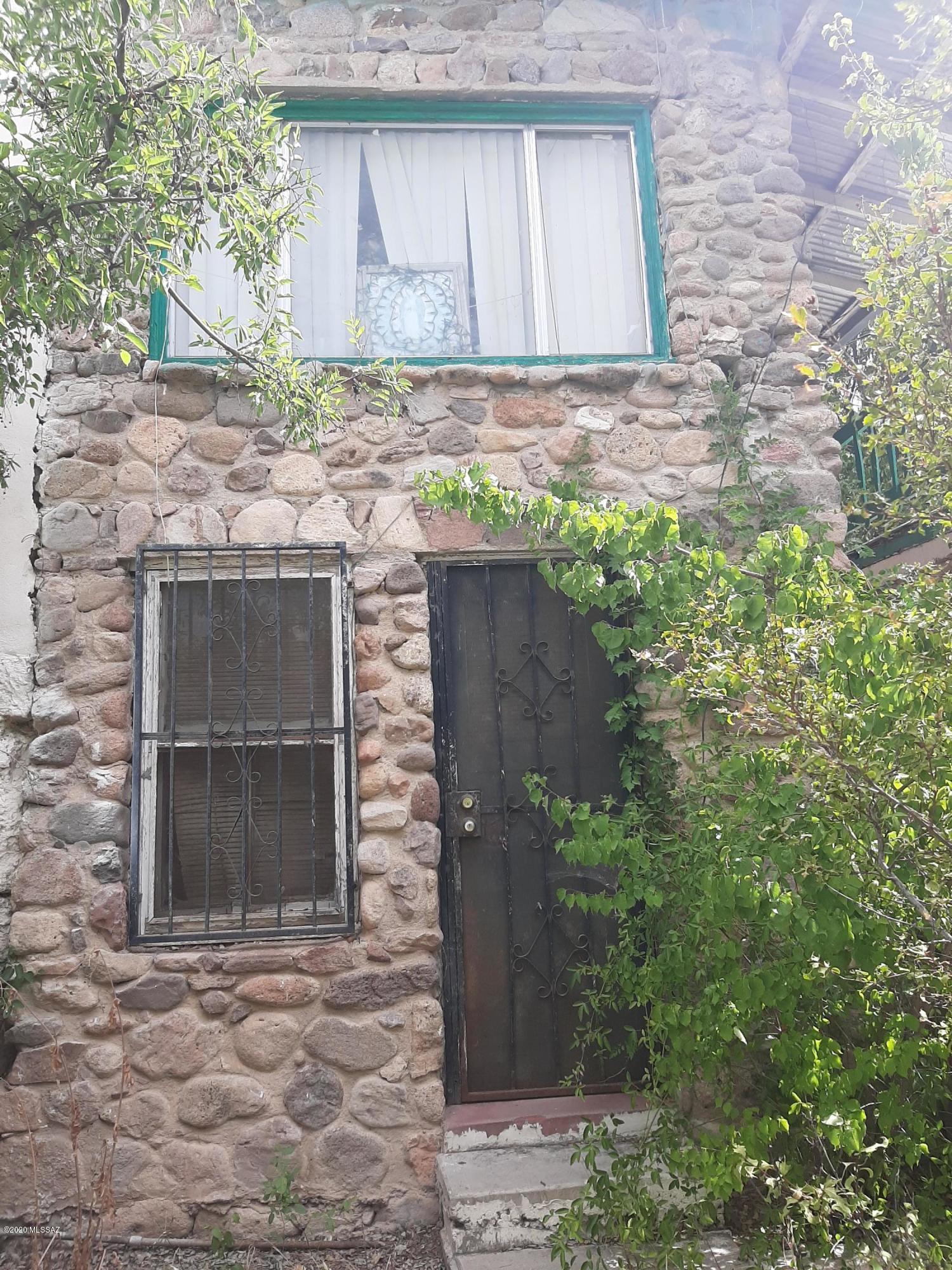 CALLING ALL INVESTORS!!! This historically built home sits up high on a hill and has great potential to be an awesome home! So, roll up your sleeves, bring your imagination and skills, and make this one someones dream home! Huge rock built storage room just below house has potential for extra living space/guest house. Main house has high ceilings, solid block construction, and is currently set up as a 3 bed room 1 bath with attached guest quarters that has 1 bed room, 1 bath, living room and kitchen. Main house also has a huge open room/basement that can be potentially made into living space. Take advantage of this potentially great investment opportunity located in the rolling hills of Downtown Nogales! As-Is Sale.