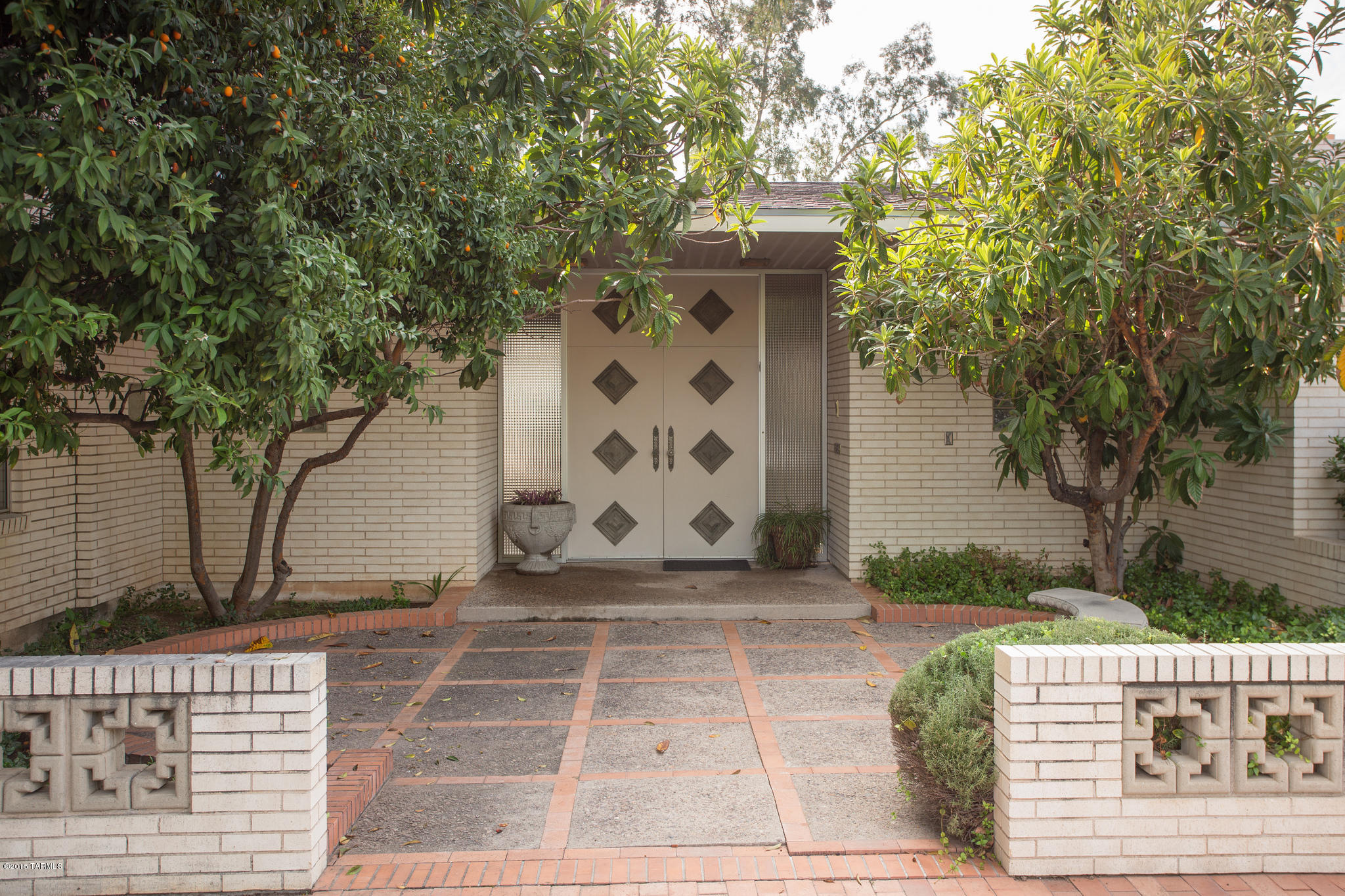 Nestled in El Encanto, this 1966 Mid Century Modern Home retains all its original details: from the St. Charles Kitchen to the elegant curved staircase in the grand foyer (w/elevator for convenience). Formal living, dining & breakfast rooms.  Lovely wood shelved-lined library, an expansive family/game room complete with fireplace, bar, & pool table.  Guest bedroom and 1-1/2 baths on main floor and 4 bedrooms/3 baths upstairs.  The yard features a beautiful mosaic tile lap-size pool, courtyard ramada and a park-like separate yard that offers views from the living room. This is a rare find with so many original amenities intact!  Total Retro ambiance!