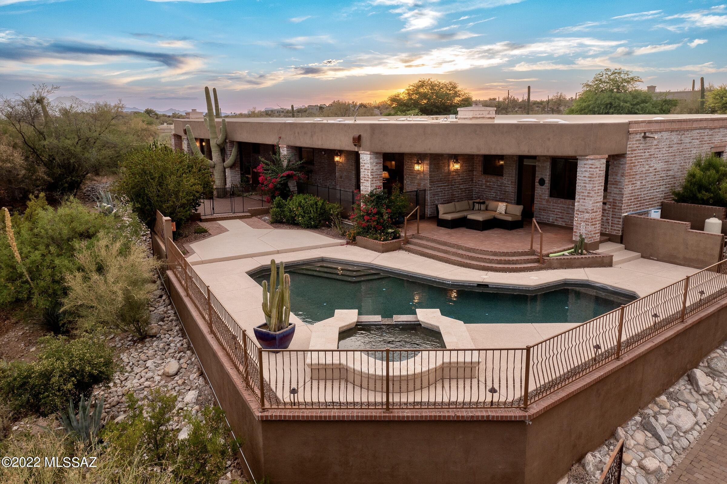 Surround yourself in new heights of luxury at this stunning Mediterranean burnt adobe home. Tucked away on a secluded lot, you will enjoy the immense mountain views & sparkling city lights. Upon entry, the long paver driveway will lead to a courtyard with soothing rock water features and a beautiful iron door that opens up to a combination of textures, finishes & a warm palette of unmatched architectural mastery. The dedicated living spaces include: an office with custom carved bookshelves, a formal dining area featuring a wine wall & a family room with a wet bar. The Gourmet kitchen, perfect for any chef, boasts an oversized center-island, rough cut edge granite countertops, stainless appliances and customized vent. The primary suite finds a cozy fireplace, large walk-in custom closet & access to a private patio to enjoy all the sunset views. There are three additional en-suite bedrooms & one with its own covered patio. This site was beautifully designed for indoor/outdoor entertainment with resort style living. Retreat outdoors to multiple covered patios, a refreshing pool & spa, 2 fire features plus a putting green.