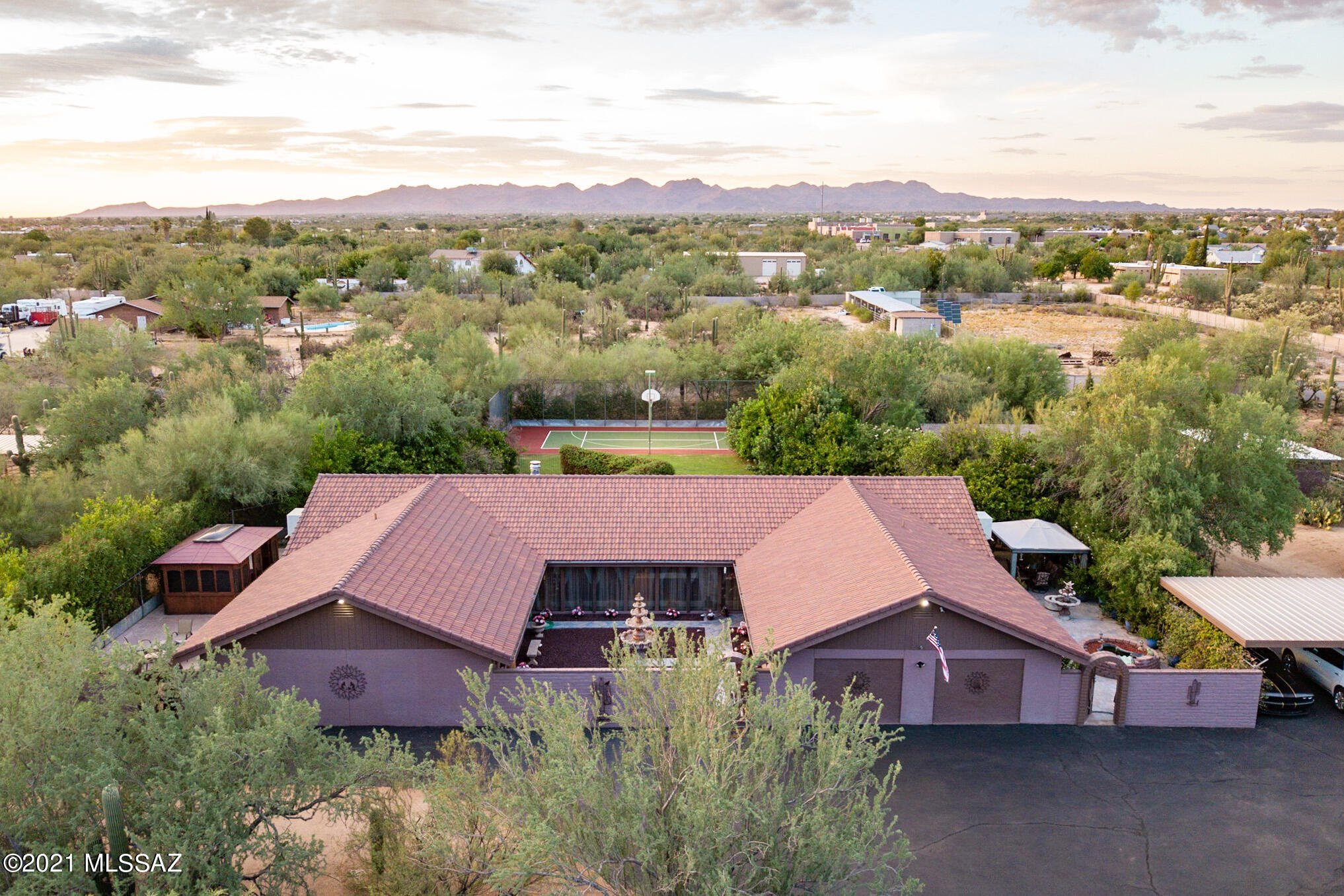 It's a ranch, it's a luxury home, it's a resort... YES, it is all of the above. Enter through a private gate that takes you to your secluded estate. A serene courtyard with a relaxing water feature greets your guests as they enter this incredible home. 4011 square foot main home and a 672 square foot guest house. This is a perfect multigenerational home.  The grounds are one of a kind, lush and green and the home is on a well. As you enter the front door you'll notice the custom tongue and grove redwood throughout the large family and formal dining rooms. Enjoy the ambiance from the handmade, wood burning Cantera stone fireplace. Almost like a western resort, this home offers a self cleaning pool with electric safety cover, newly resurfaced sports court, full security system with cameras. The grounds are home to an abundance of mature citrus trees, enclosed jacuzzi, fire pit, koi fish pond, huge manicured grass area, and of course an area for your horses, goats, and chickens!

This stunning home offers a huge master bedroom with 2 separate bathrooms that each include their own jetted tub, as well as separate closets. The spacious kitchen is made for entertaining featuring a double oven, granite transformations countertops, an abundance of cabinets and extra storage. Reap the benefits of the fully functioning, low maintenance Green House and this home wouldn't be complete without the 382 sq ft workshop with rolling door. Enjoy the best life has to offer riding horses and/or off road toys on the scenic trails already created on this property! So much love has been poured into this home, you're sure to feel it the second you arrive. Sport court for tennis/basketball/volleyball and more. Go cart trails, a sparkling pool, large park-like grass area, citrus and fruit trees, private patio and a redwood gazebo covered spa. The patio features a canterra stone fireplace with built-in sound system that can be heard all over the property. Horse corral, stable and tack room are just a few of the features that are a huge bonus for the lucky new home owner.