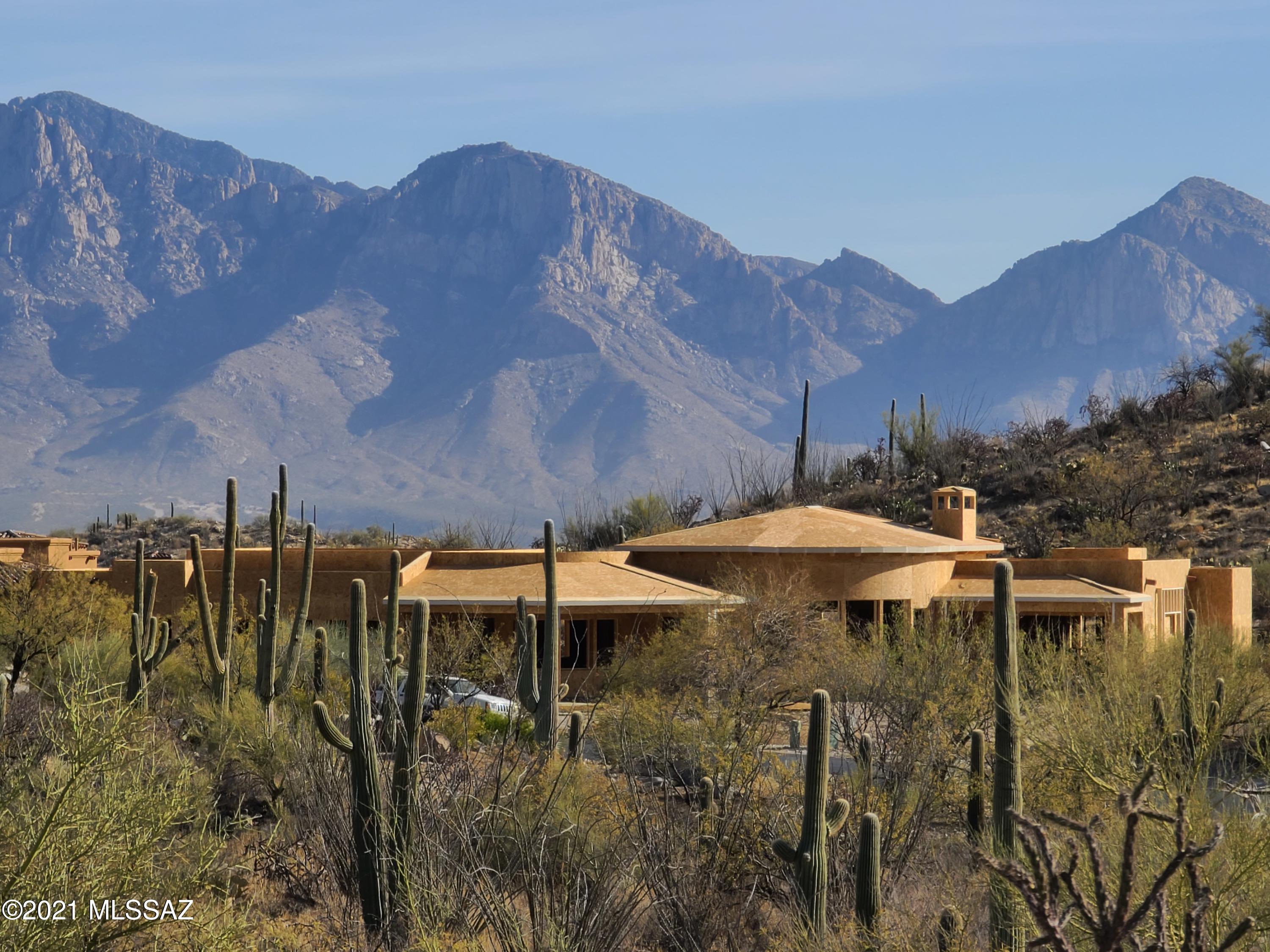 Architectural form of Tuscany structures in the old world style home with an an Arizona twist, featuring variations in ceiling heights, casual Great room living area including a wall of windows, an adjacent cook's kitchen with Wolf and SubZero, nook, formal dining room, plus French doors to the large covered patio and mountain views. Flexible rooms for everyday functions with an abundance of natural light! Master bedroom suite with French doors leads to its private covered patio, split ensuite bedrooms 2 and 3, Guest bedroom, and 8' solid wood knotty alder doors accessing the office/den. Complete with Travertine floors, granite counters, large laundry room, oversize 3 car garage, BBQ station, pool and spa, perimeter block/stucco wall. It's a complete time-tempered lifestyle on 1.75 acres.