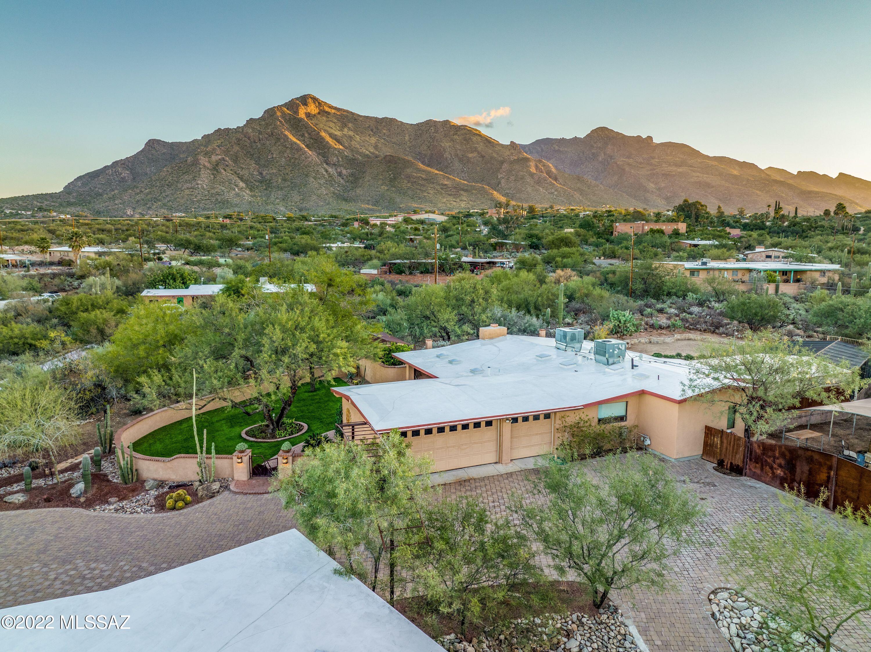 Tucked away in the highly sought after Suffolk Hills neighborhood is this immaculately maintained 3 bed 2 bath home sitting on 1.2 acres and surrounded by breathtaking views of the Catalina Mountains.  This gorgeous home features granite counters, stainless steel appliances, professional landscaping, a gated custom brick driveway as well as a gated and covered RV parking area with electrical hookup including multiple 220V service outlets on the property. Also featured is a pool, custom hickory and cherry wood cabinets as well as solid alder wood doors in main house.   Guest house features 1 guest bath, 1 full bath in bedroom, large living and kitchen area, and custom alder wood doors and cabinets.  Guest home has its very own yard, laundry room, garage, deck, and a basement with ext access