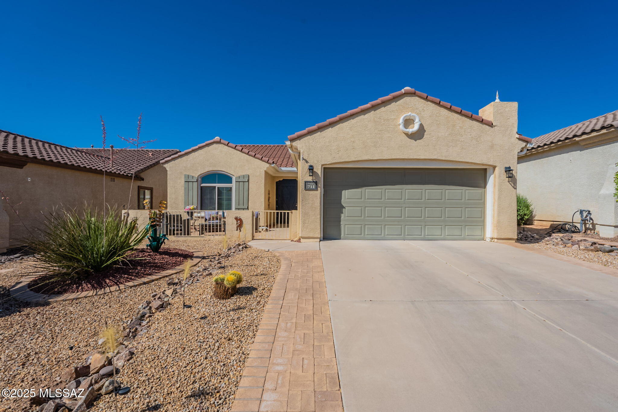 Located in the highly sought-after 55+ community of Sonora at Rancho Sahuarita, this beautifully maintained home offers a blend of comfort, style, and active adult living. Enjoy exclusive access to private amenities and walk to pickleball and bocce ball courts, a sparkling pool and spa, a fitness center, and a clubhouse with a full calendar of monthly events.

The enclosed front courtyard is perfect for sipping your morning coffee, chatting with neighbors, and keeping your furry companions safe. Inside, you'll find tile and laminate wood flooring throughout, a well-appointed kitchen with a center island, Corian countertops, a gas range, and newer Frigidaire refrigerator and LG microwave.

The guest bathroom features a striking tiled accent wall, a shower/tub combo, and a framed mirror. Milgard windows provide energy efficiency, and the laundry room includes a newer Samsung dryer and extra storage cabinets. Both bathrooms are equipped with grab bars for added peace of mind.

The third bedroom offers flexibility as a home office or cozy den. The backyard is an entertainer's dream, with flagstone pavers creating multiple seating areas, a raised flower bed, AstroTurf for easy maintenance, and a grill for weekend barbecues.

The primary suite features a lovely bay window, a walk-in shower, and a spacious walk-in closet, creating a relaxing and private retreat. Routine HVAC maintenance through D&H Heating and Cooling adds to the home's thoughtful upkeep.

This property offers the best of active adult living in one of Sahuarita's most welcoming and tight-knit communities.